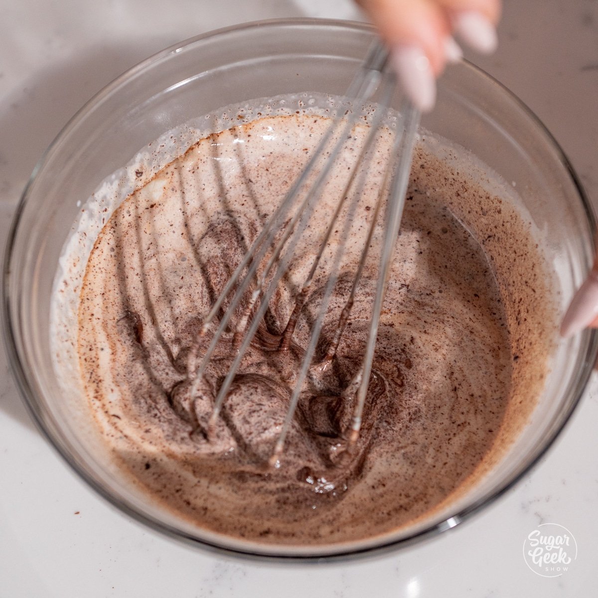 whisk bringing together chocolate and cream in a bowl