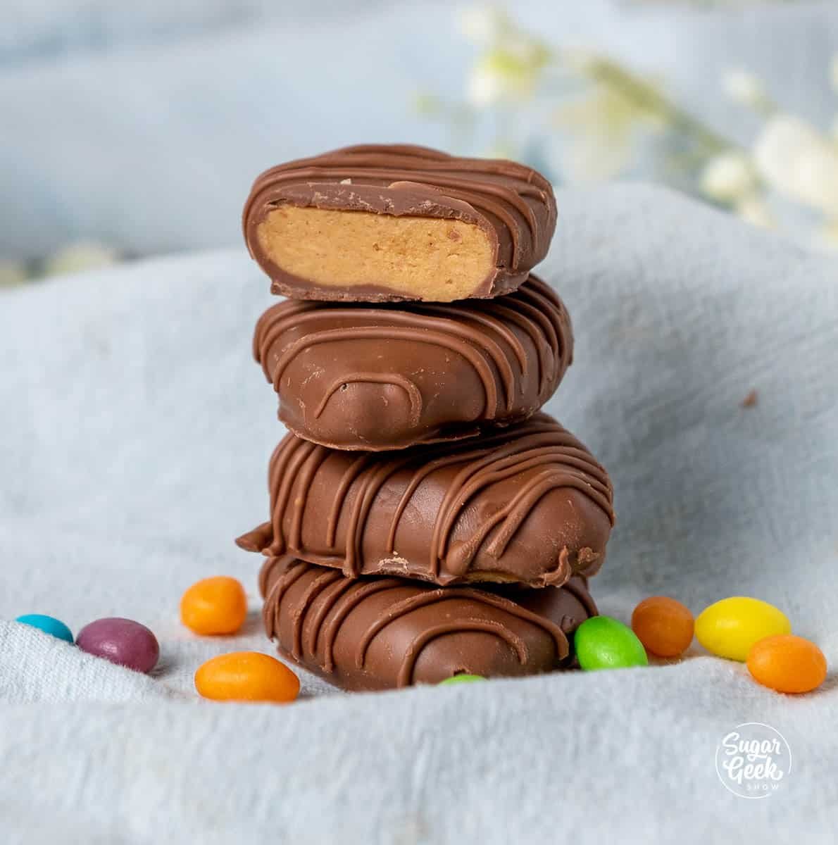 Peanut butter chocolate eggs stacked on a blue towel