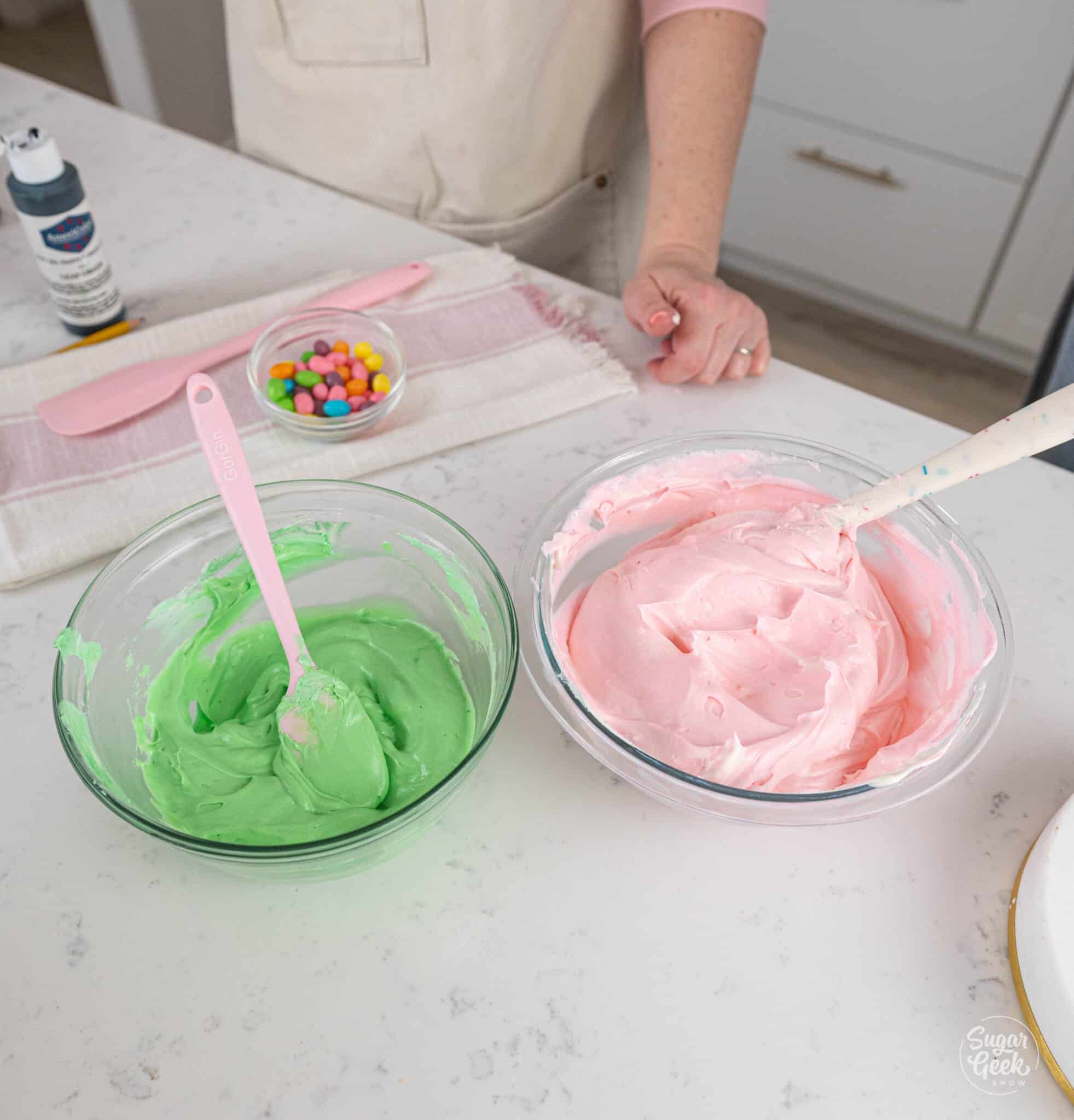 green and pink buttercream in bowls