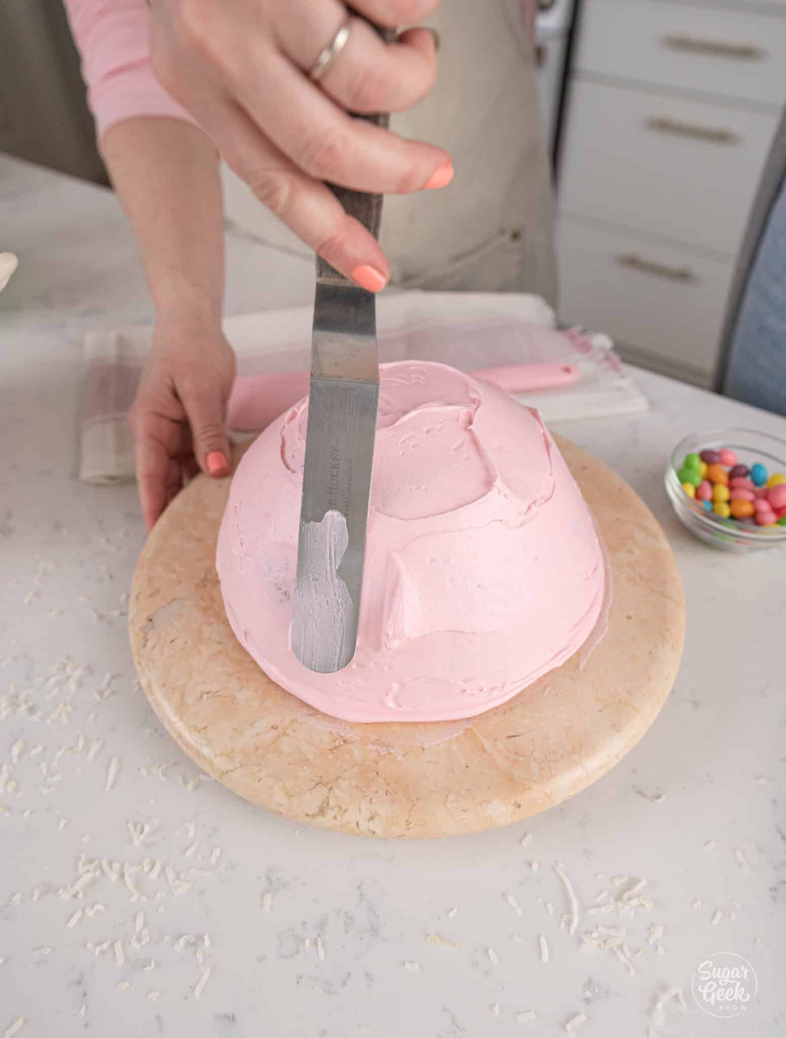 spreading buttercream on a cake