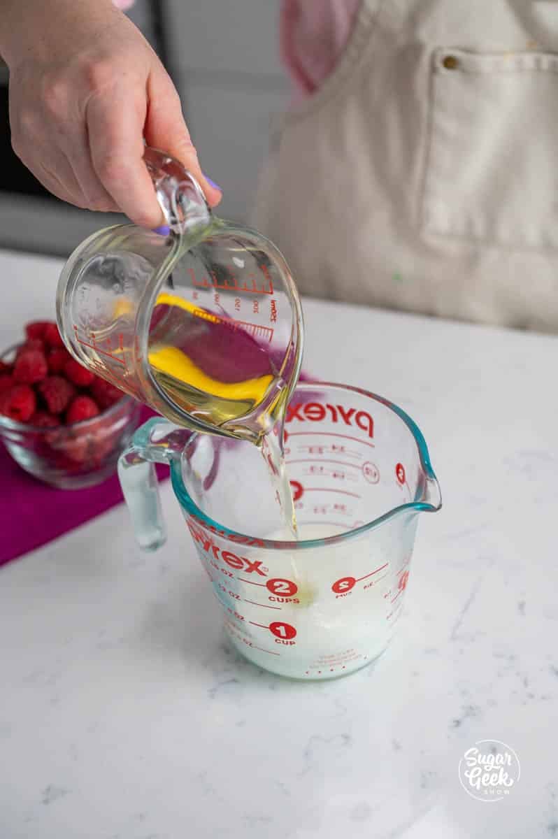 pouring oil into a measuring cup of buttermilk