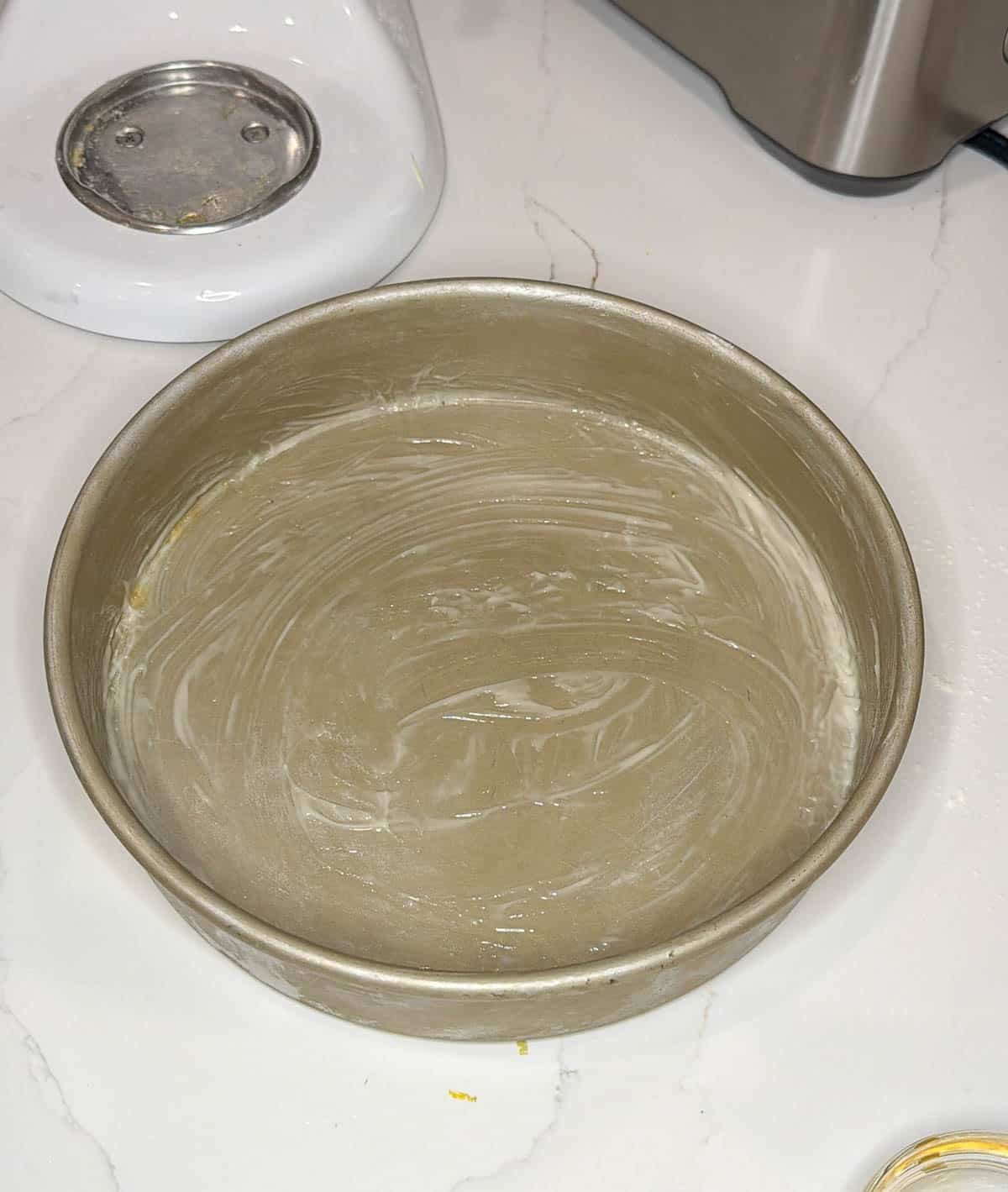 Cake pan prepared with pan release on a white countertop.