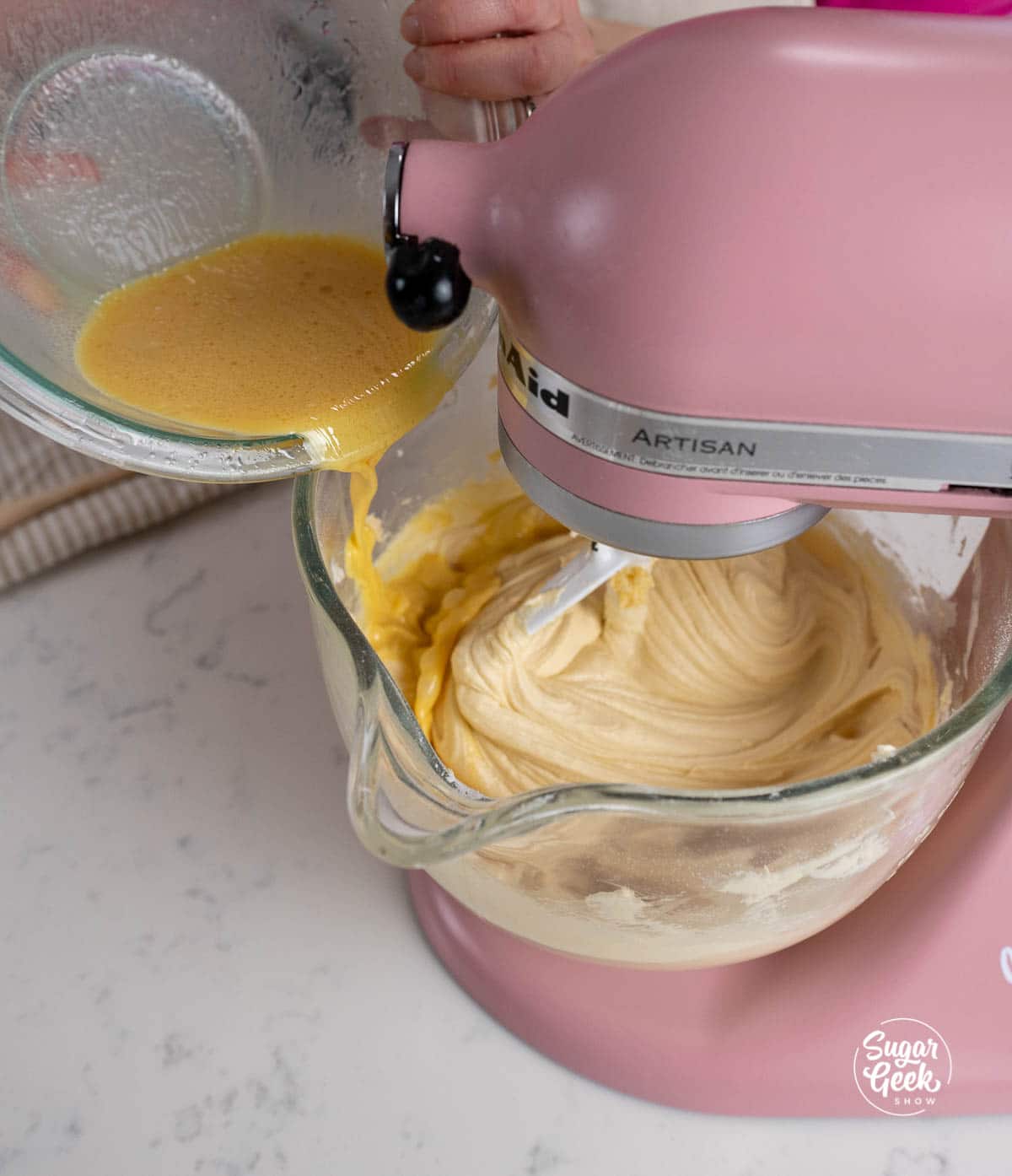 adding liquid ingredients to a stand mixer bowl
