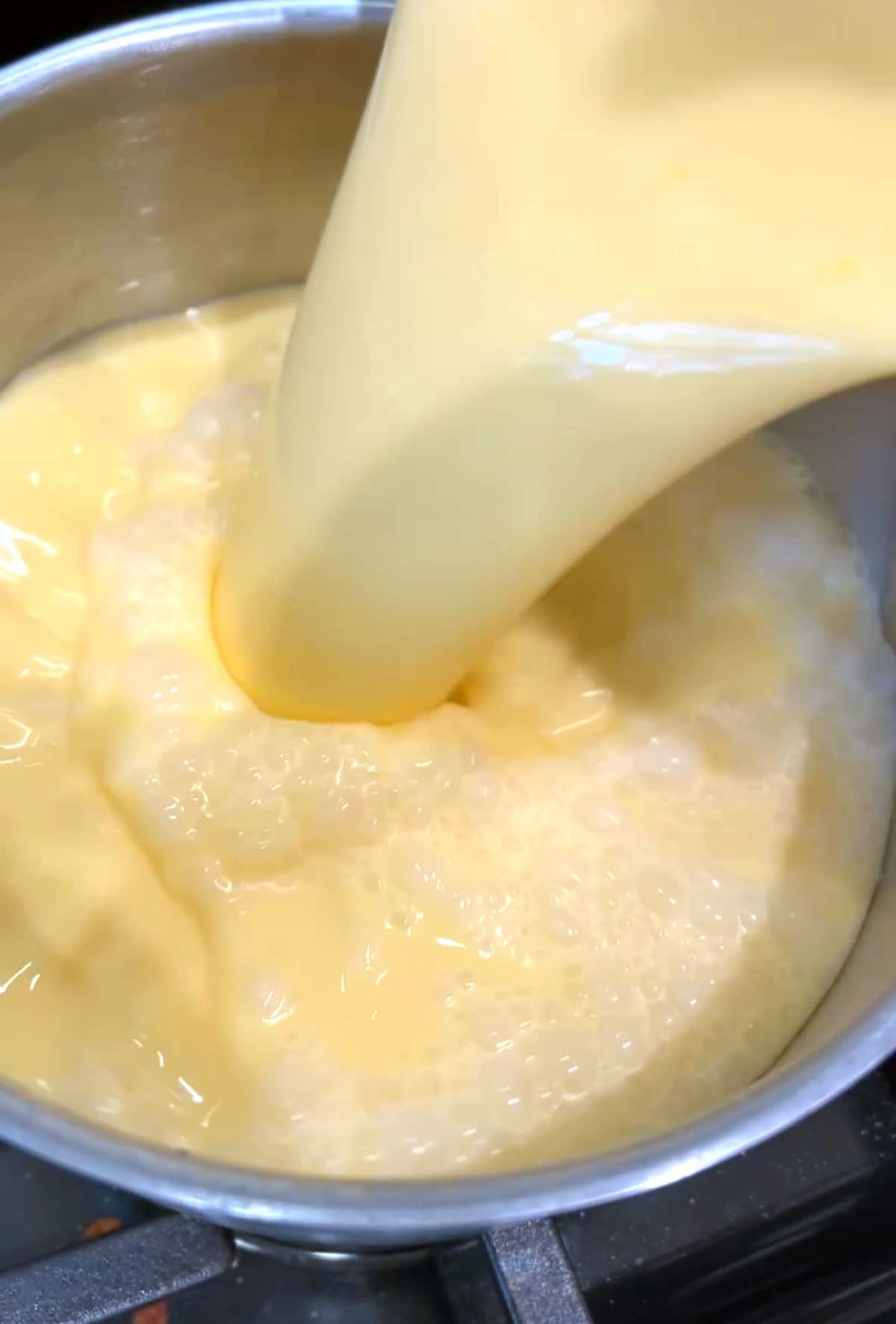 pouring lemon tart filling into a saucepan