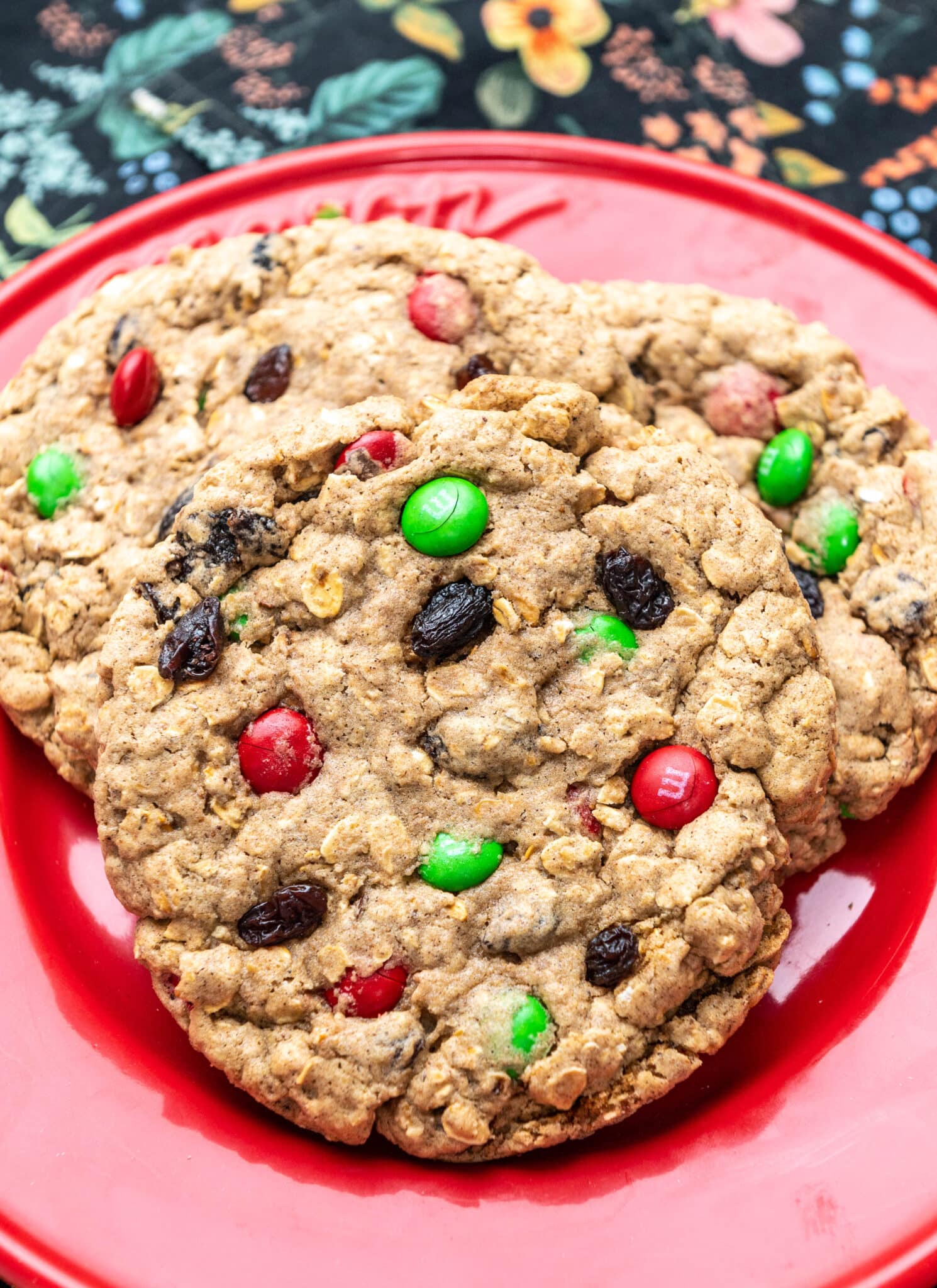 close up of oatmeal raisin m&m cookies on a red plate