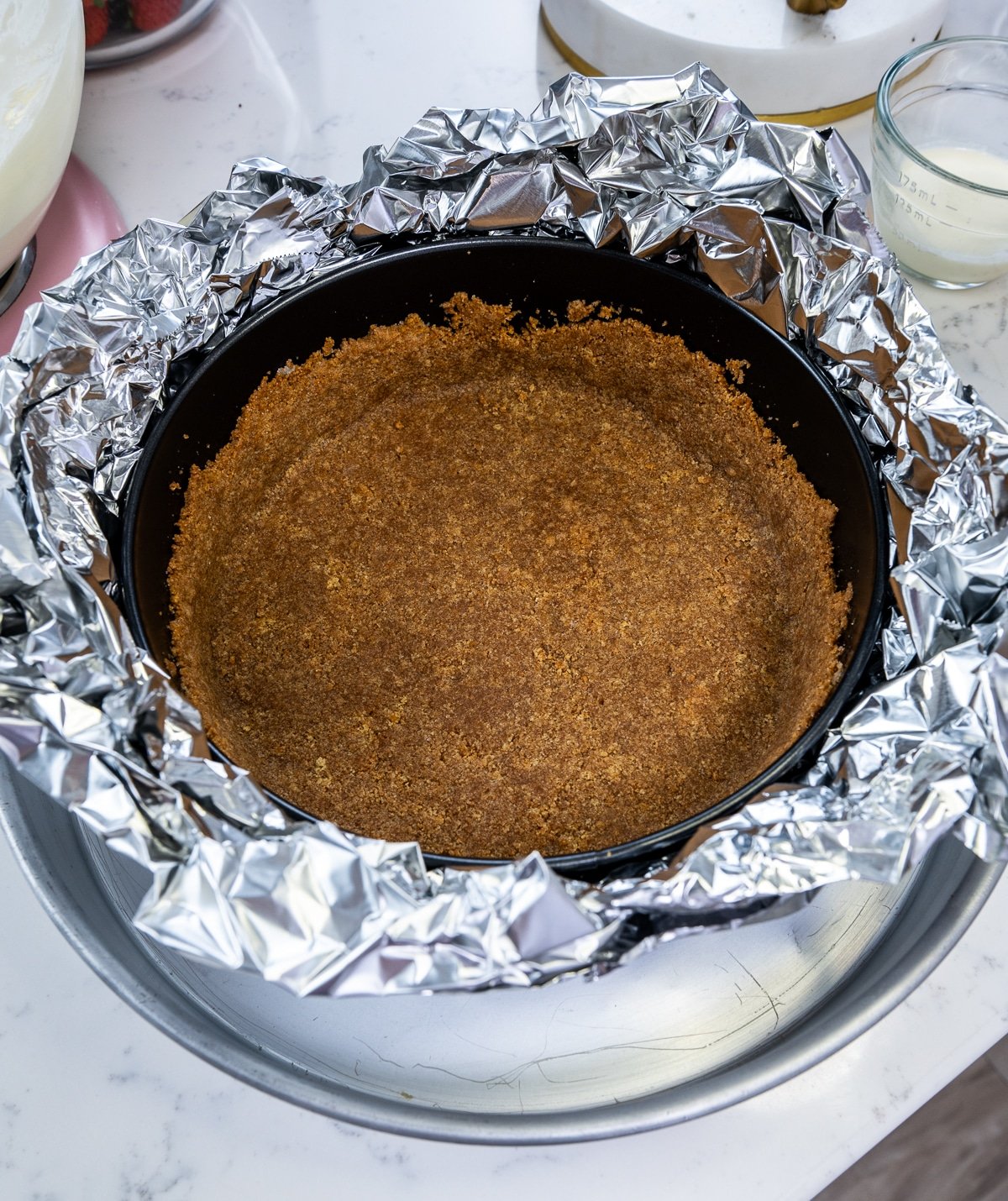 closeup of cheesecake crust wrapped in tinfoil