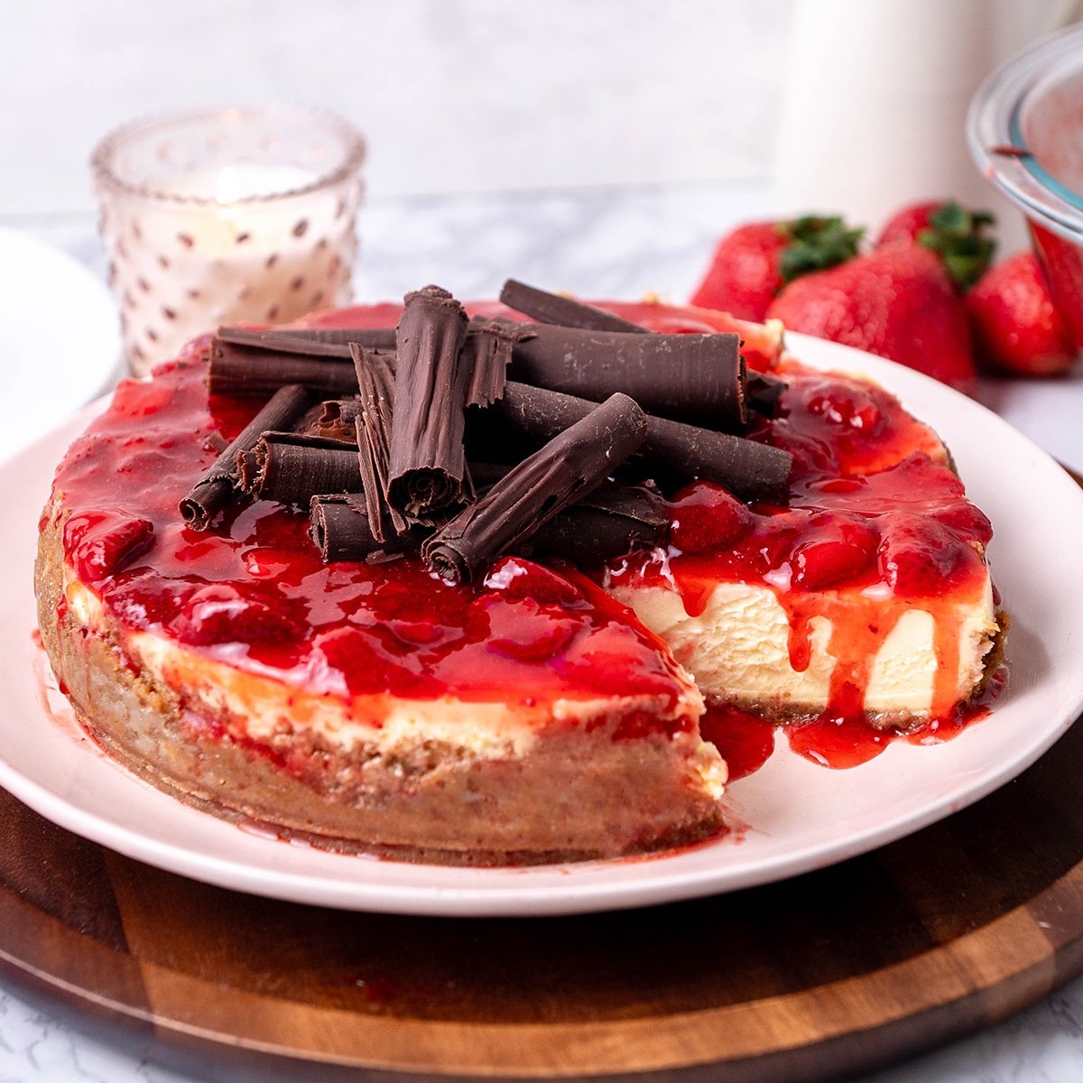 strawberry cheesecake with strawberry sauce and chocolate curls on top