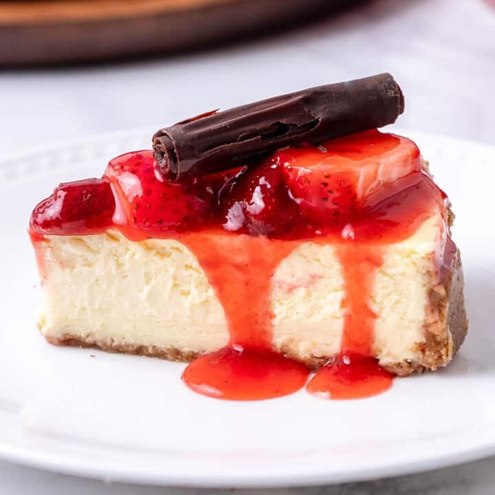 close up of a slice of cheesecake with strawberry and chocolate on top