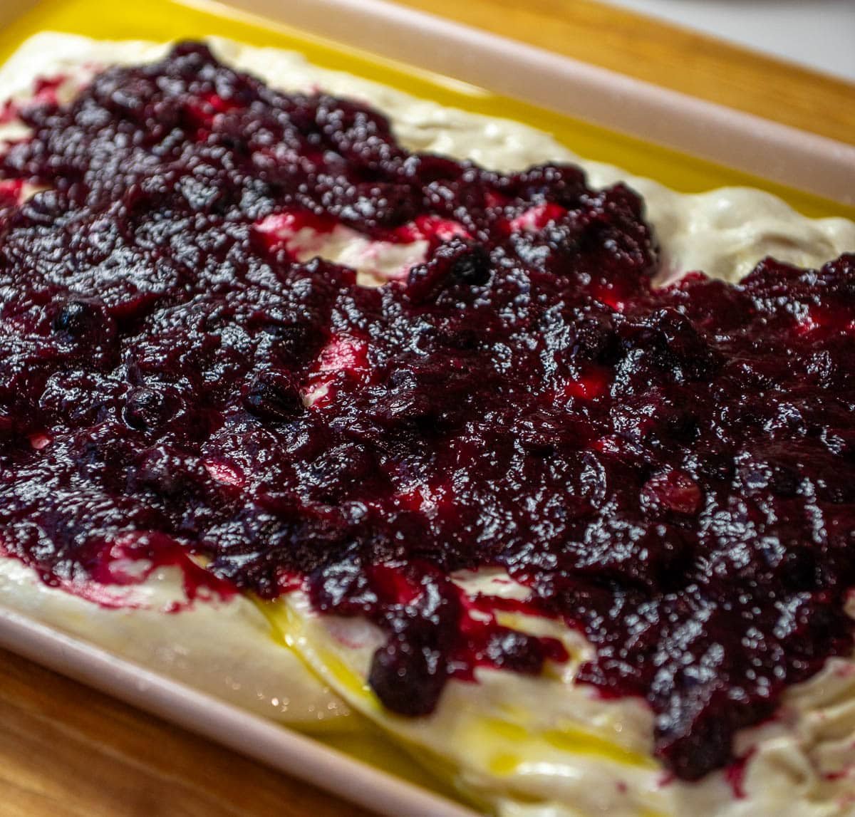 lemon blueberry sourdough focaccia on a pan with blueberry filling
