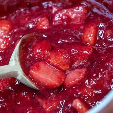 close up of strawberry topping with a wooden spoon
