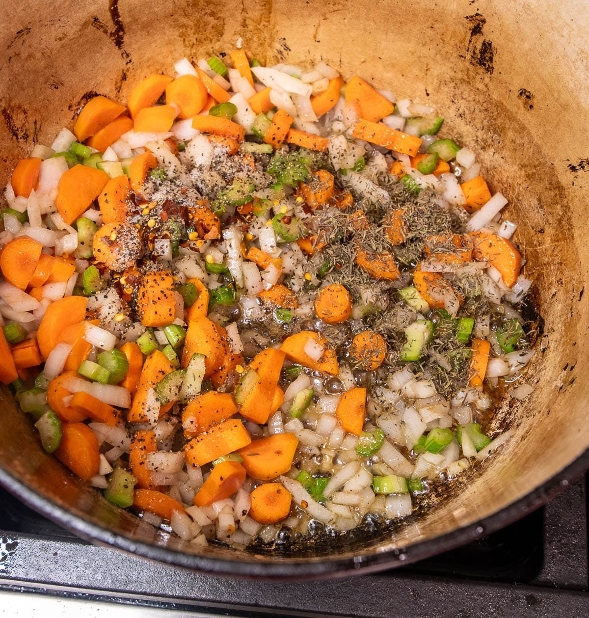 Onion, carrot, and celery added to the pot with seasoning. 