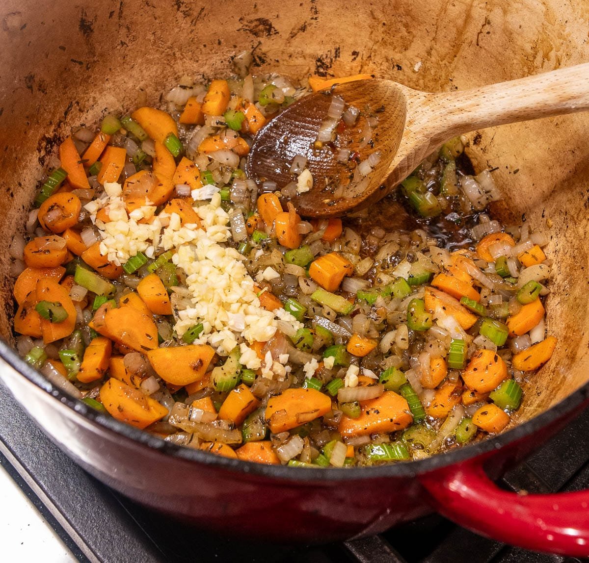 Minced garlic added to the pot of sautéed vegetables. 