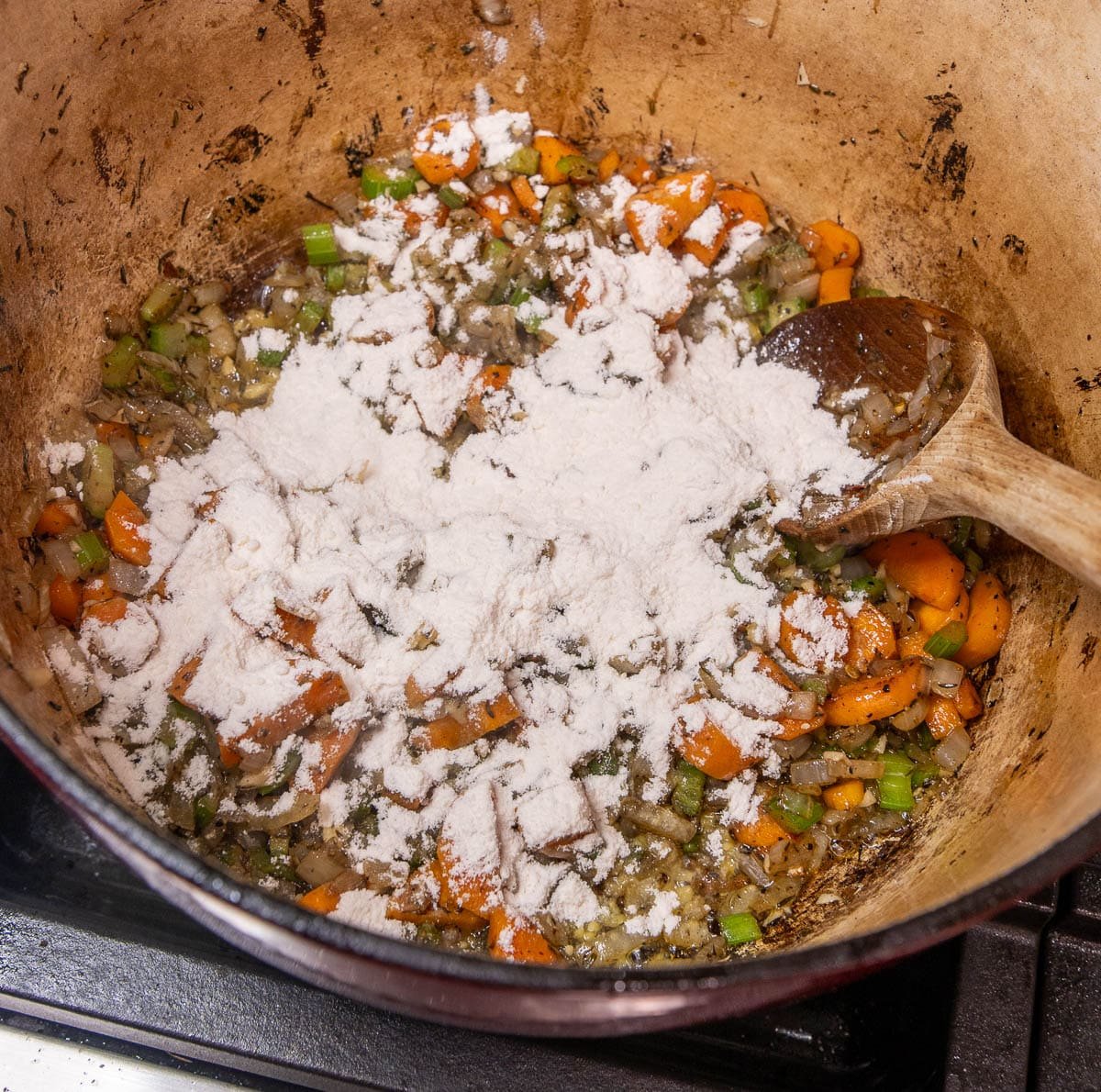 Flour added to the pot of sautéed vegetables. 
