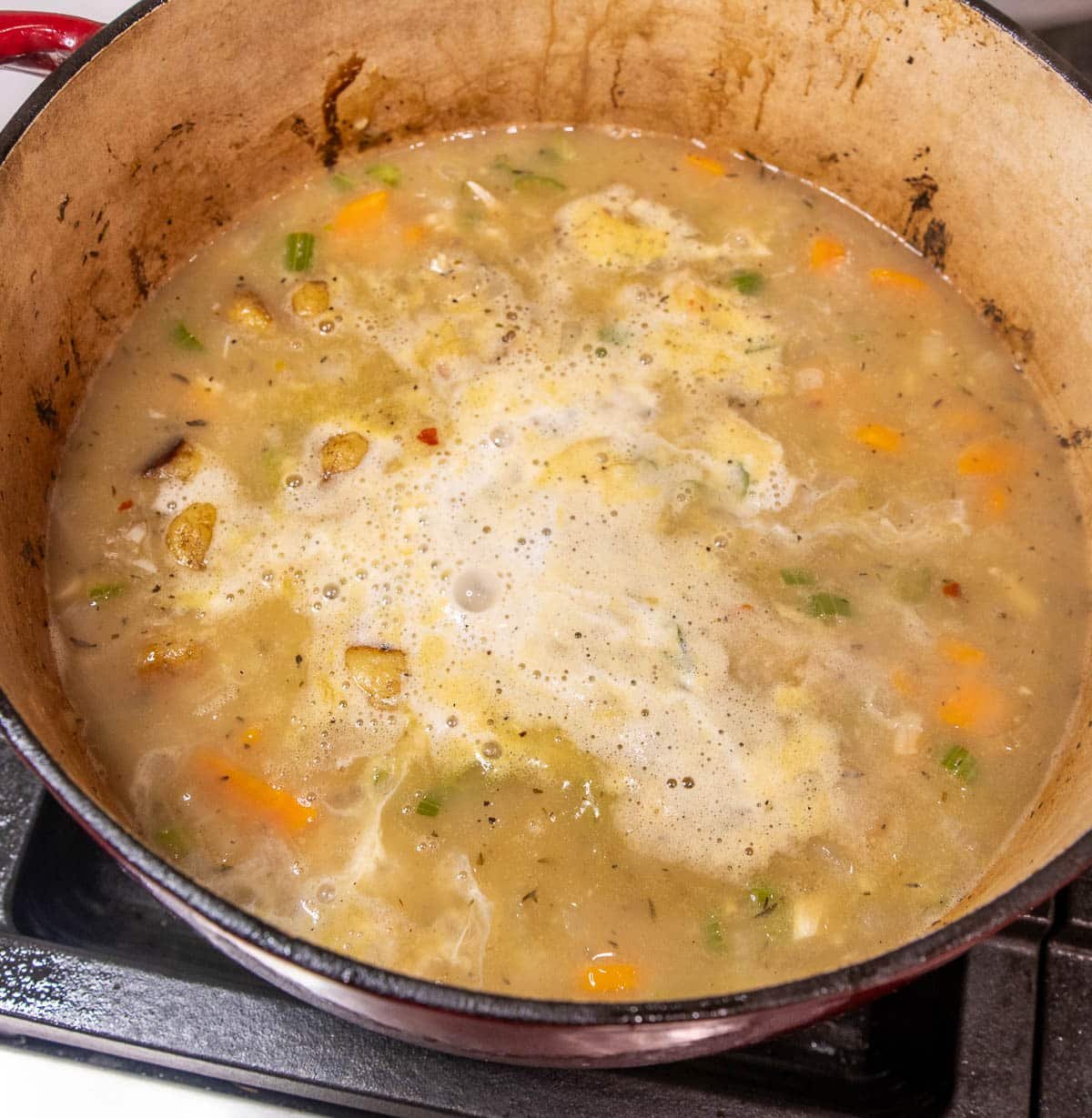 Chicken broth added to the pot of ingredients and simmering.