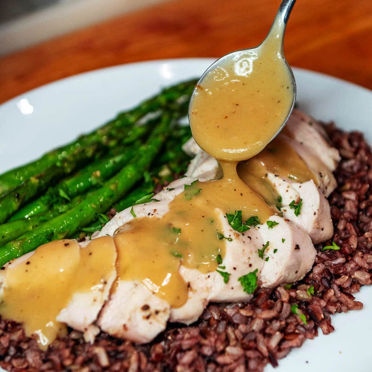 chicken gravy being spooned over chicken