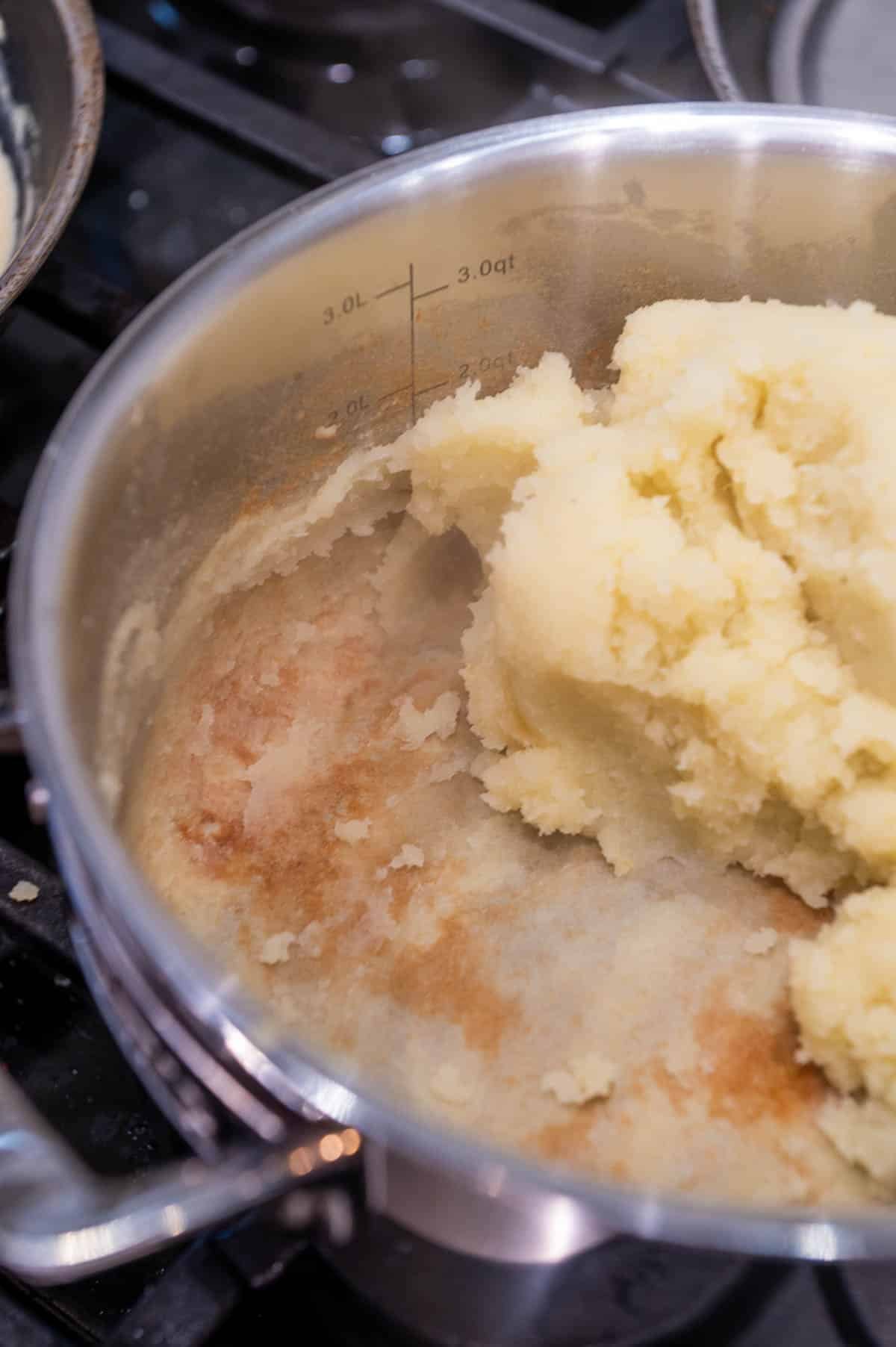 Mashed potatoes in a pot cooking out the excess moisture.