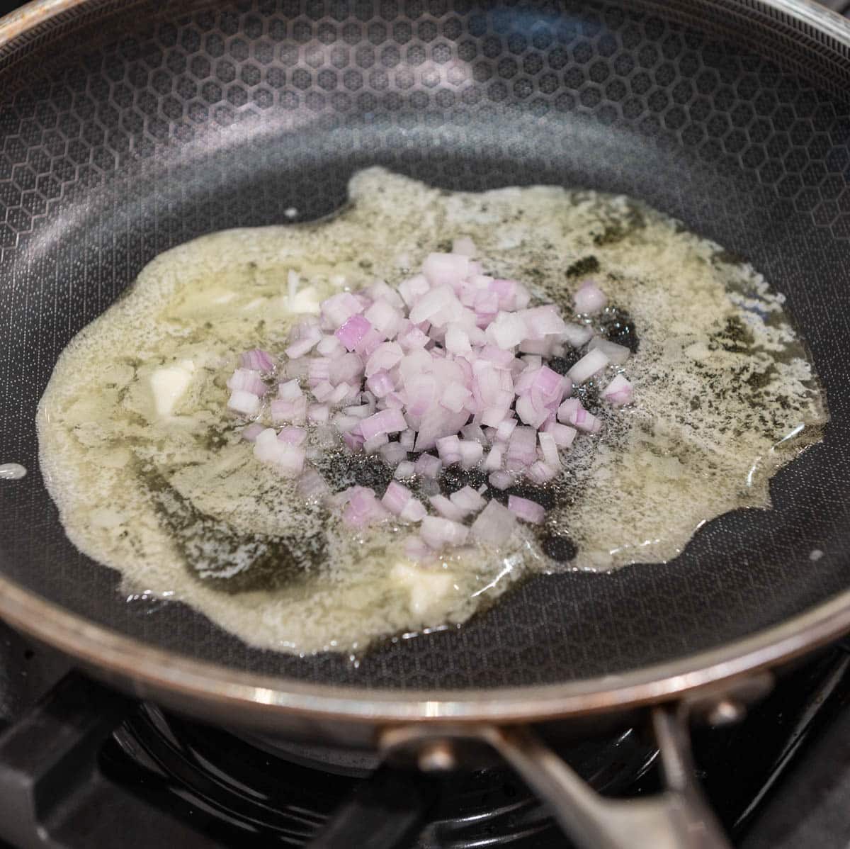 Butter and shallots in a frying pan.