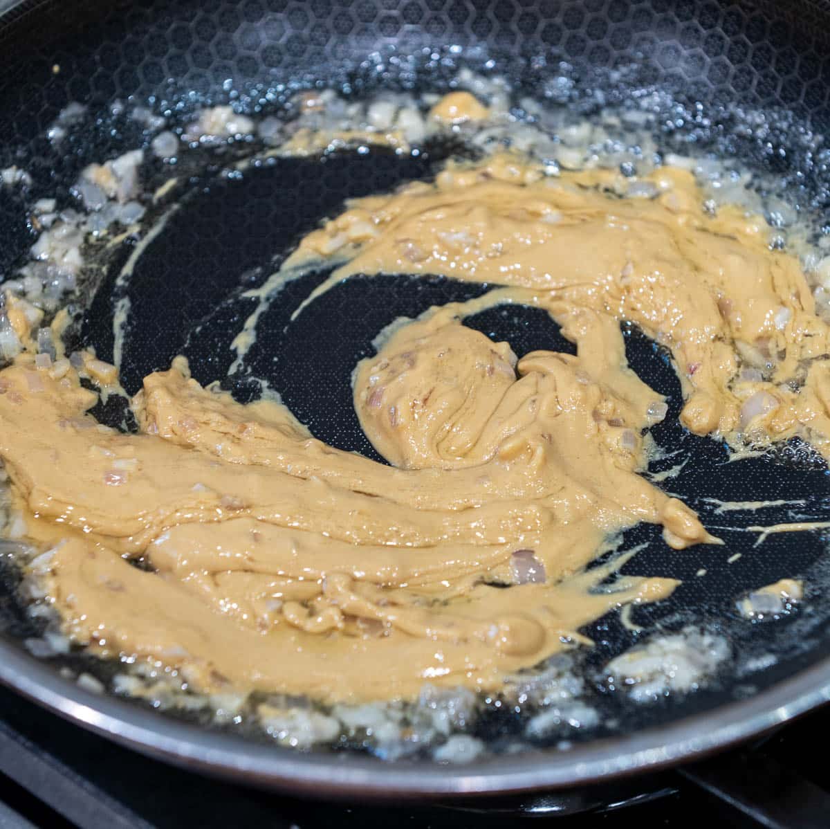 Butter and shallots in a frying pan with Dijon mustard added.