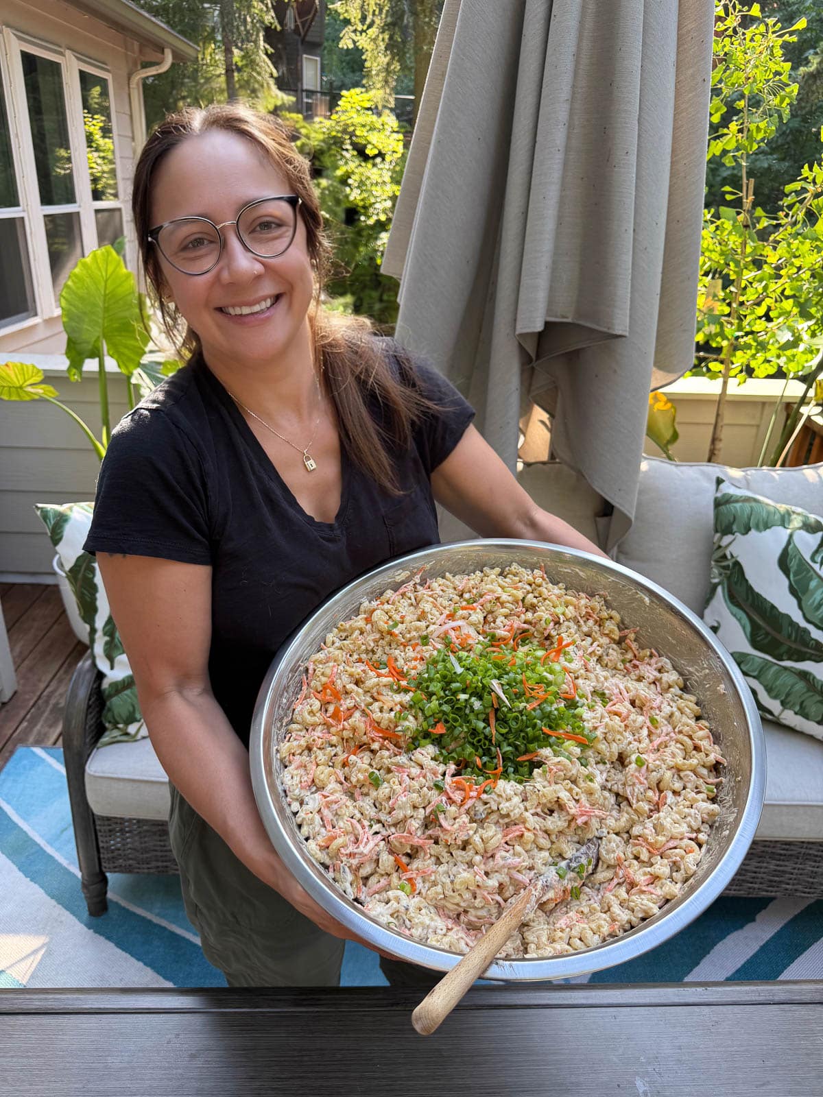 Liz smiling while holding a large bowl of Hawaiian Mac Salad.