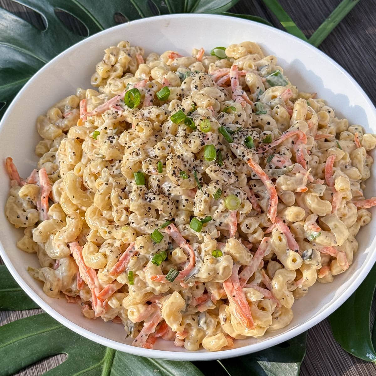 Hawaiian Mac Salad garnished with green onion slices, and in a white bowl.