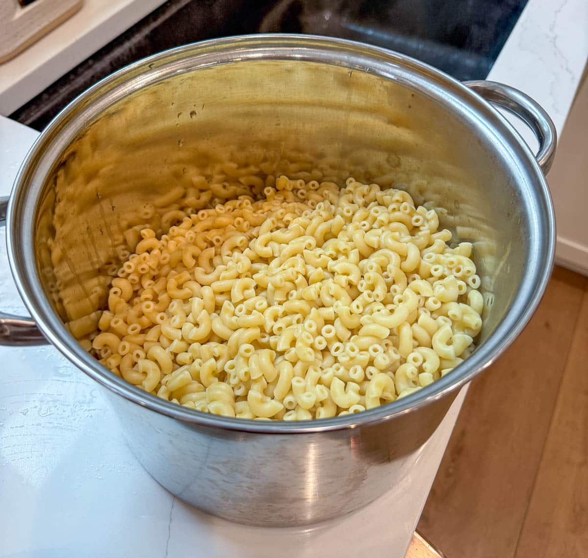 A large pot with cooked macaroni pasta in it.