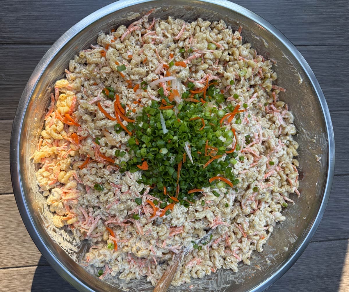 Hawaiian Mac Salad in a large bowl topped with carrots, onion, and green onion slices. 