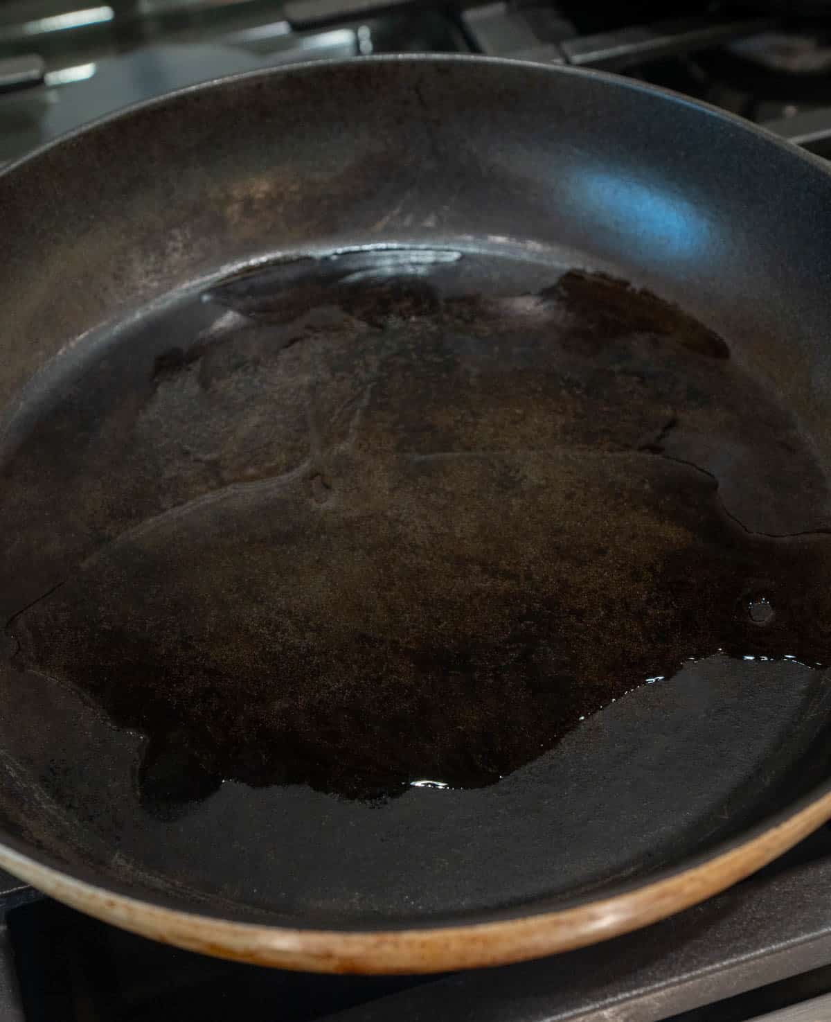 A hot pan with cooking oil in it. 