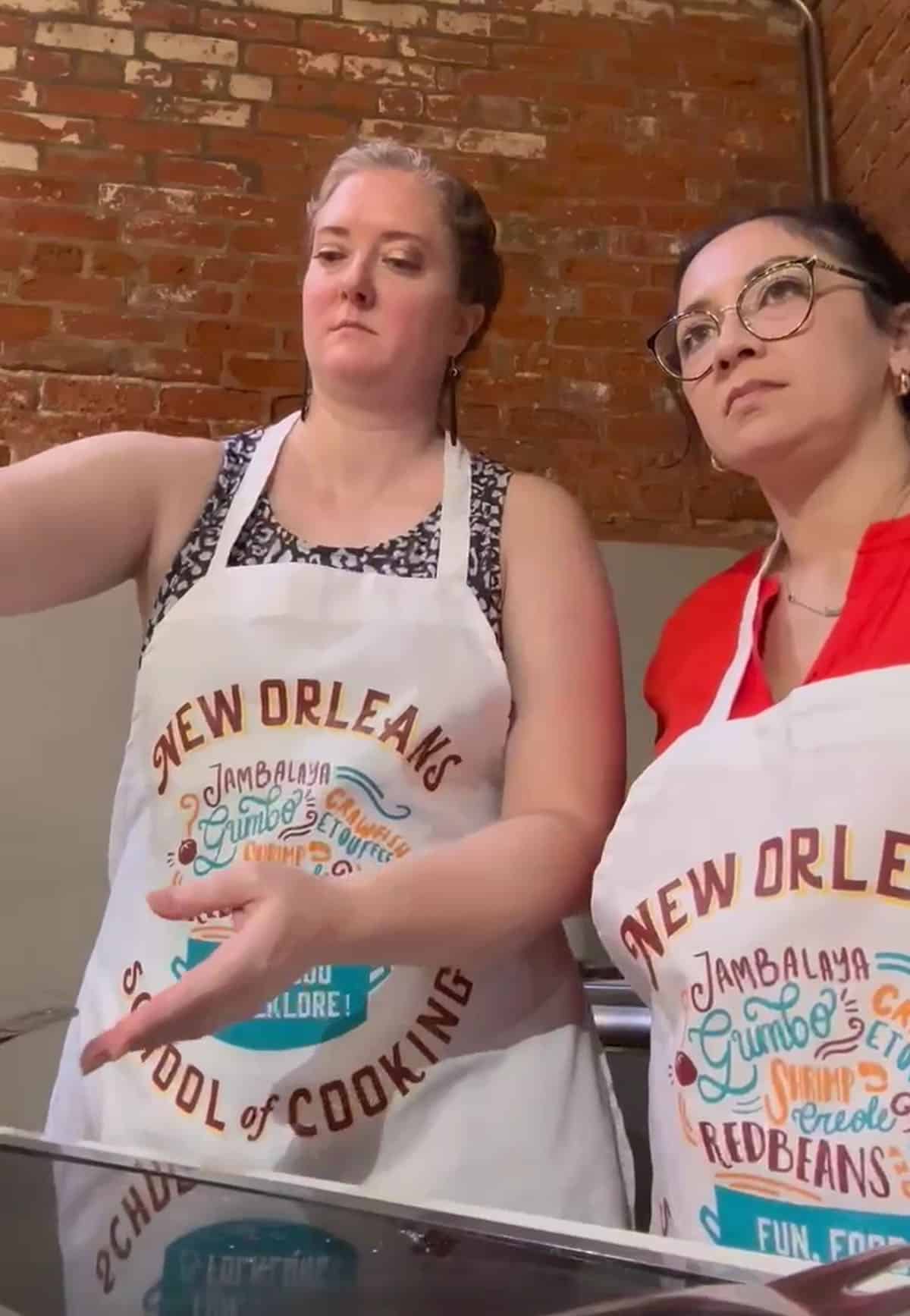 two woman in white aprons cooking