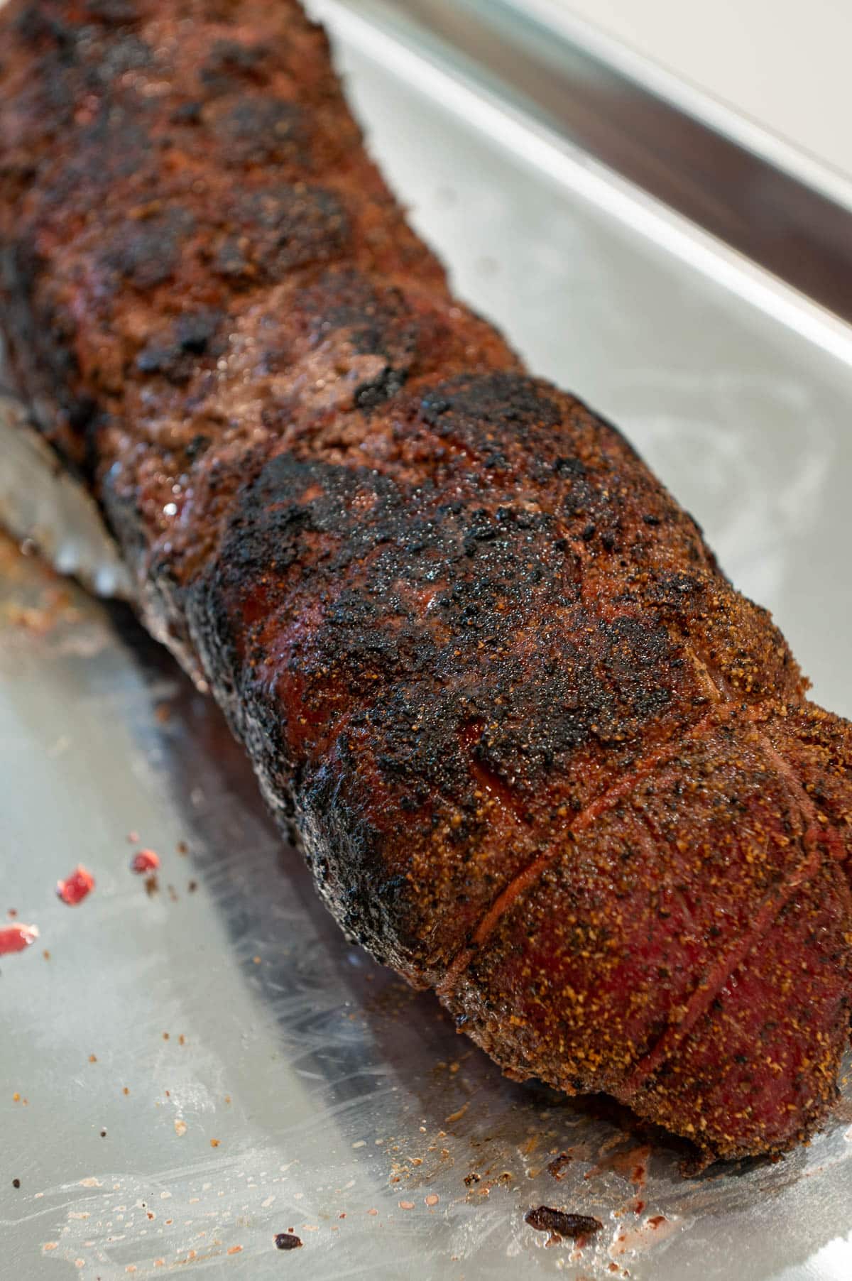 A seared whole smoked beef tenderloin with a char on the top.