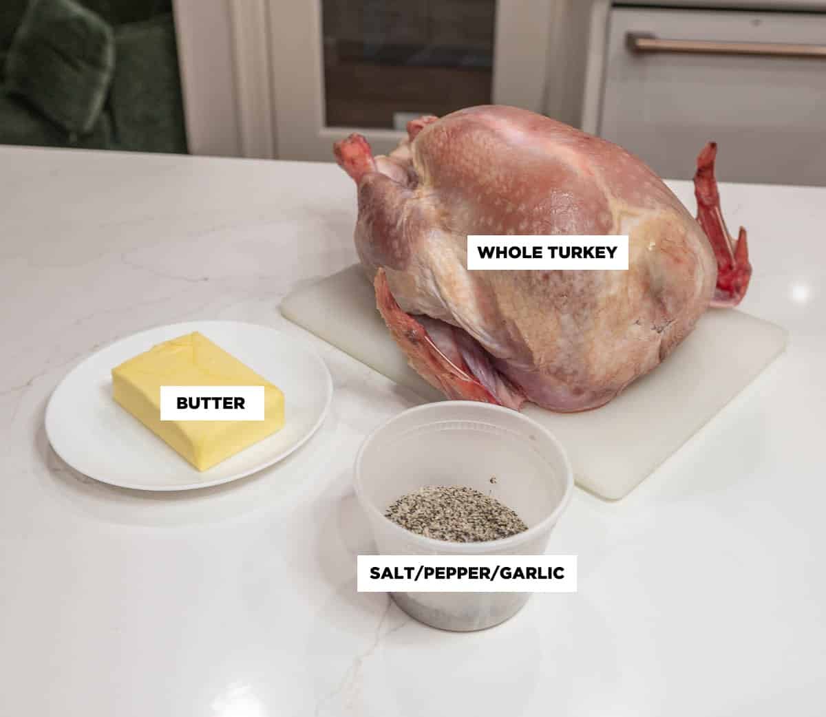 Photo of ingredients, featuring: butter, whole turkey, and a container of salt, pepper, and granulated garlic.