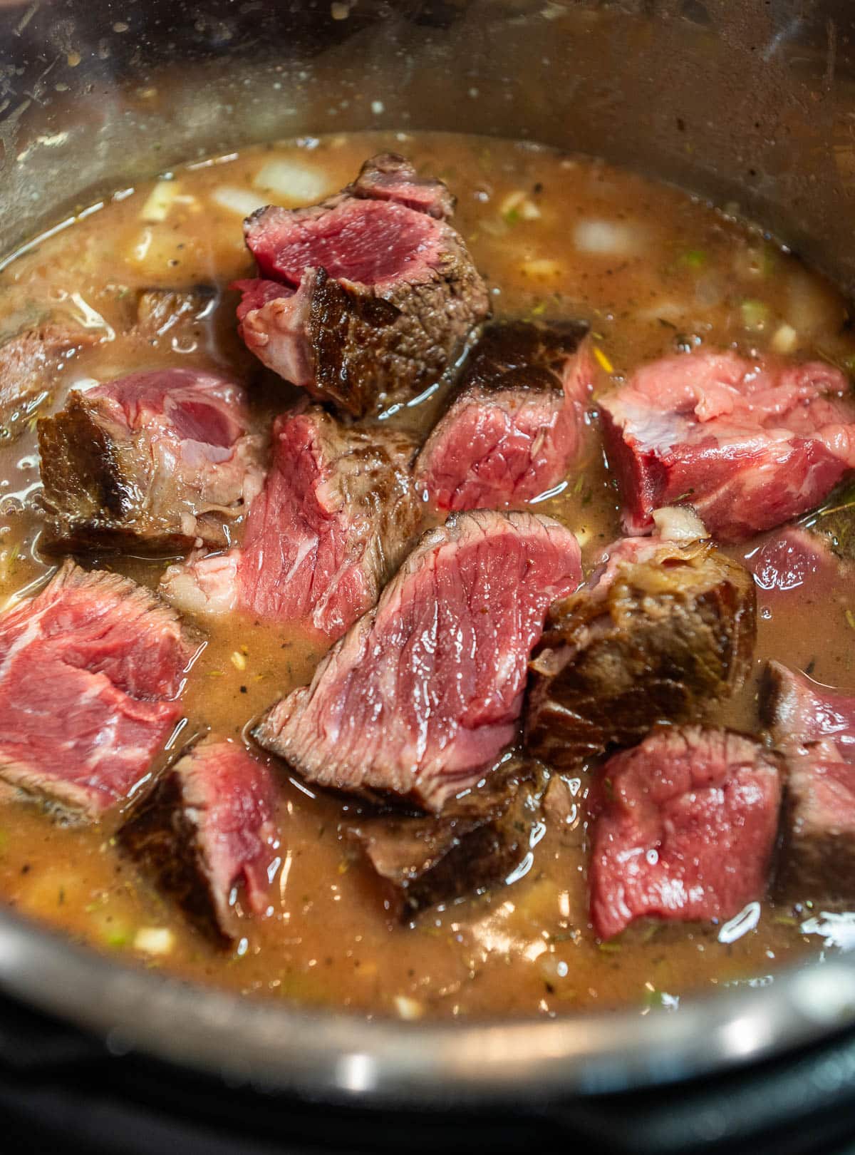 The browned beef is added to the pot.