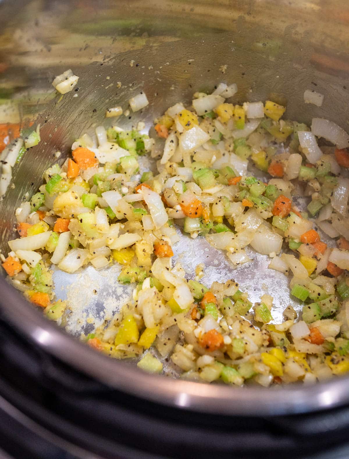 Vegetables and spices are being sautéed with butter and garlic.