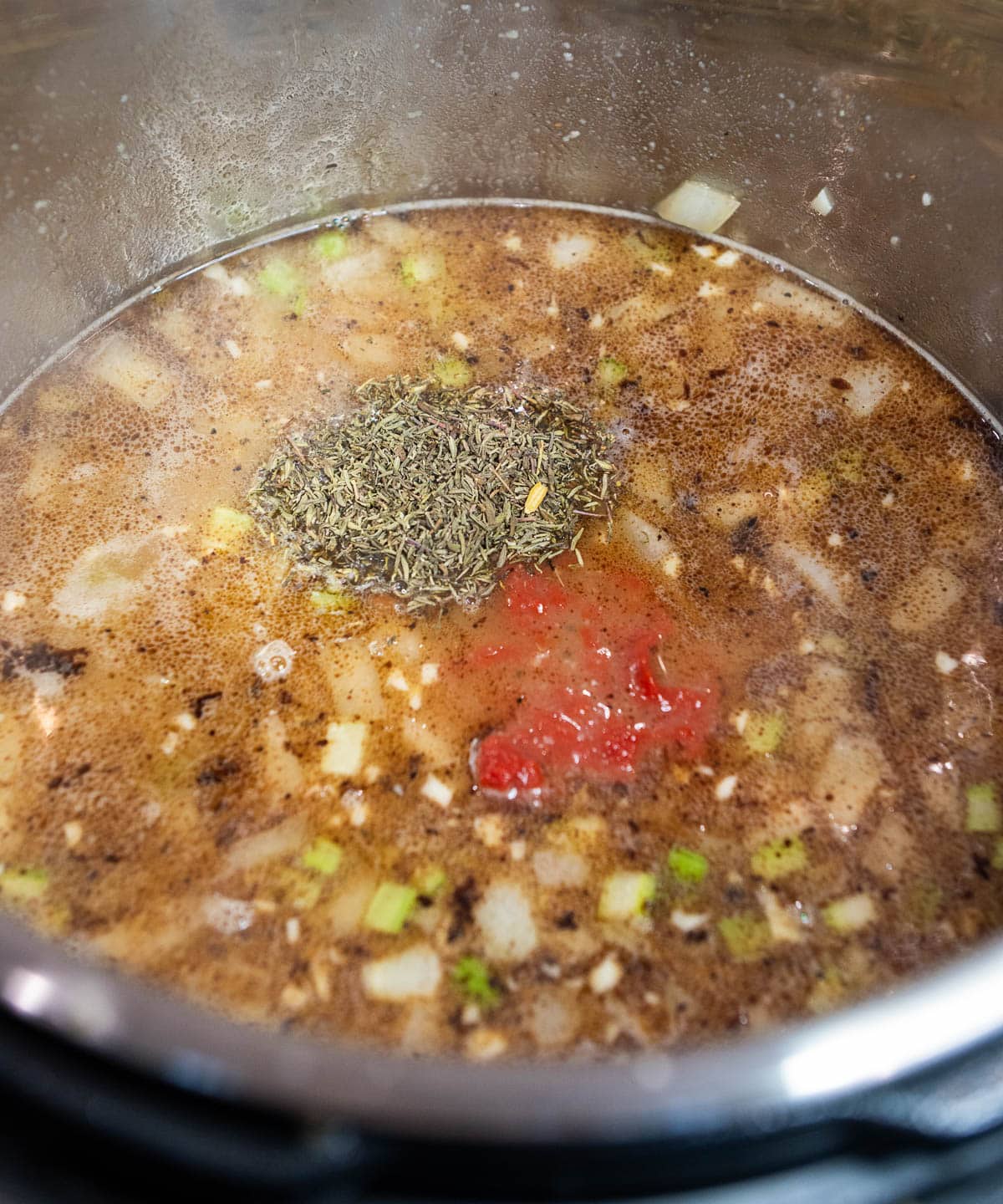 The remaining broth and the rest of the spices and tomato paste are added.