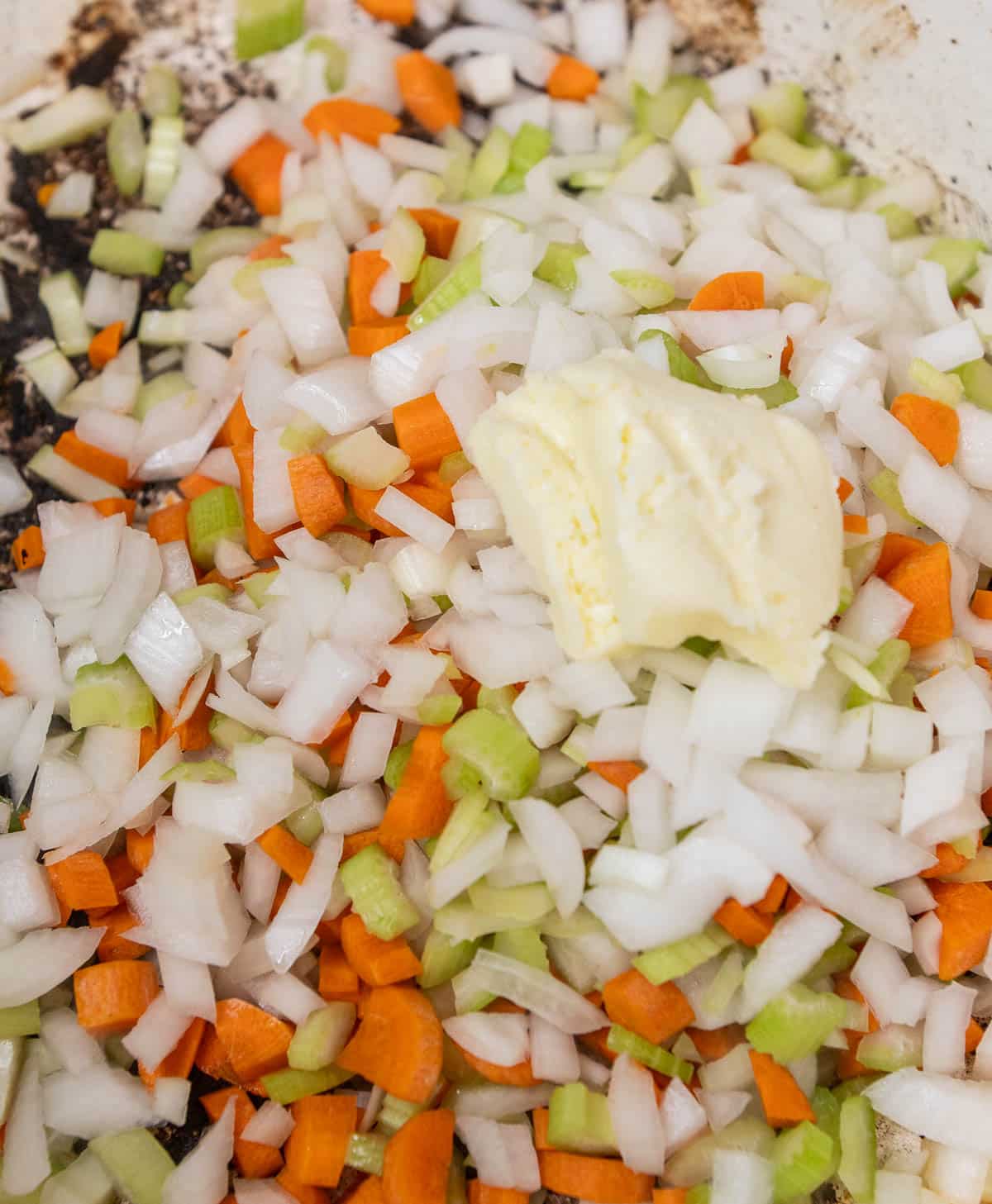 Mirepoix in a dutch oven with butter added on top.