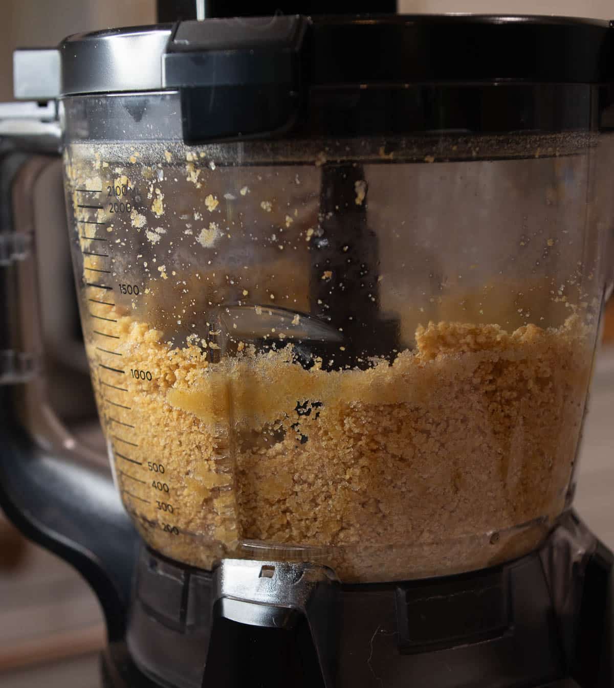 Food processor with ingredients for the graham cracker crust. 