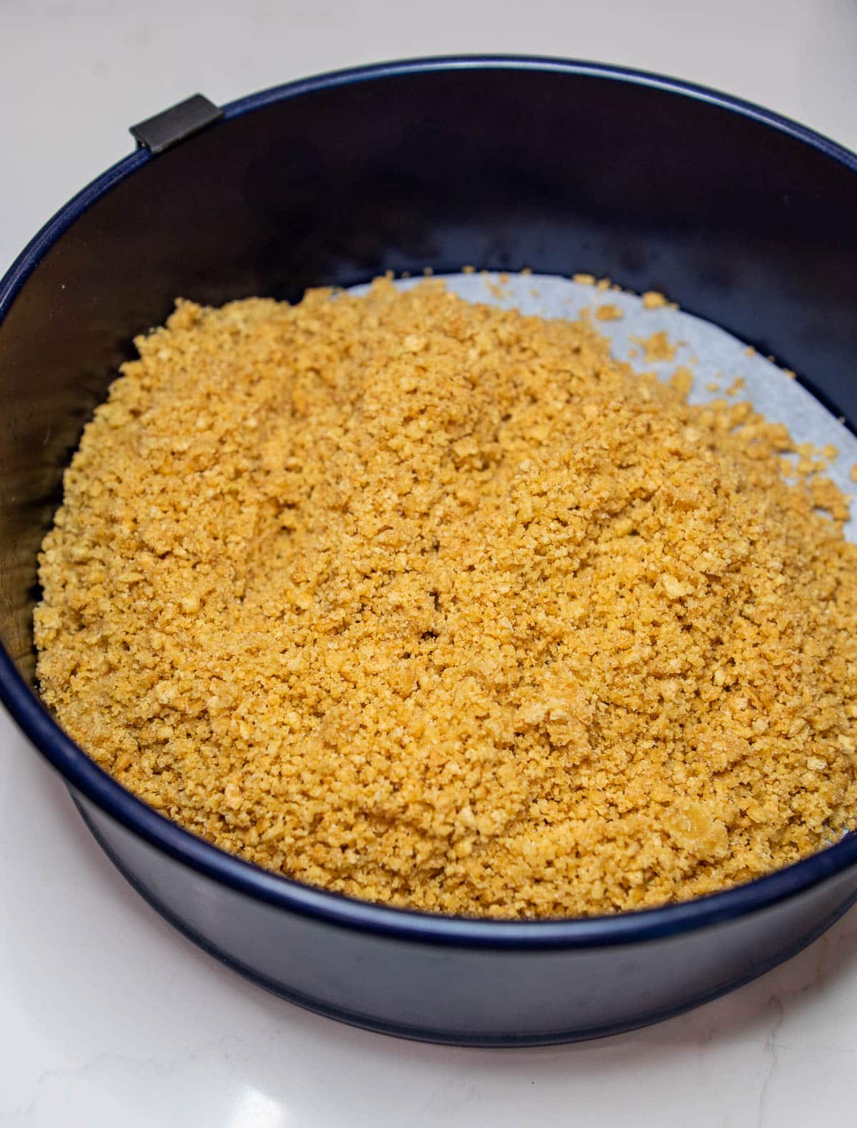 Graham cracker crust ingredients in a spring-form pan. 