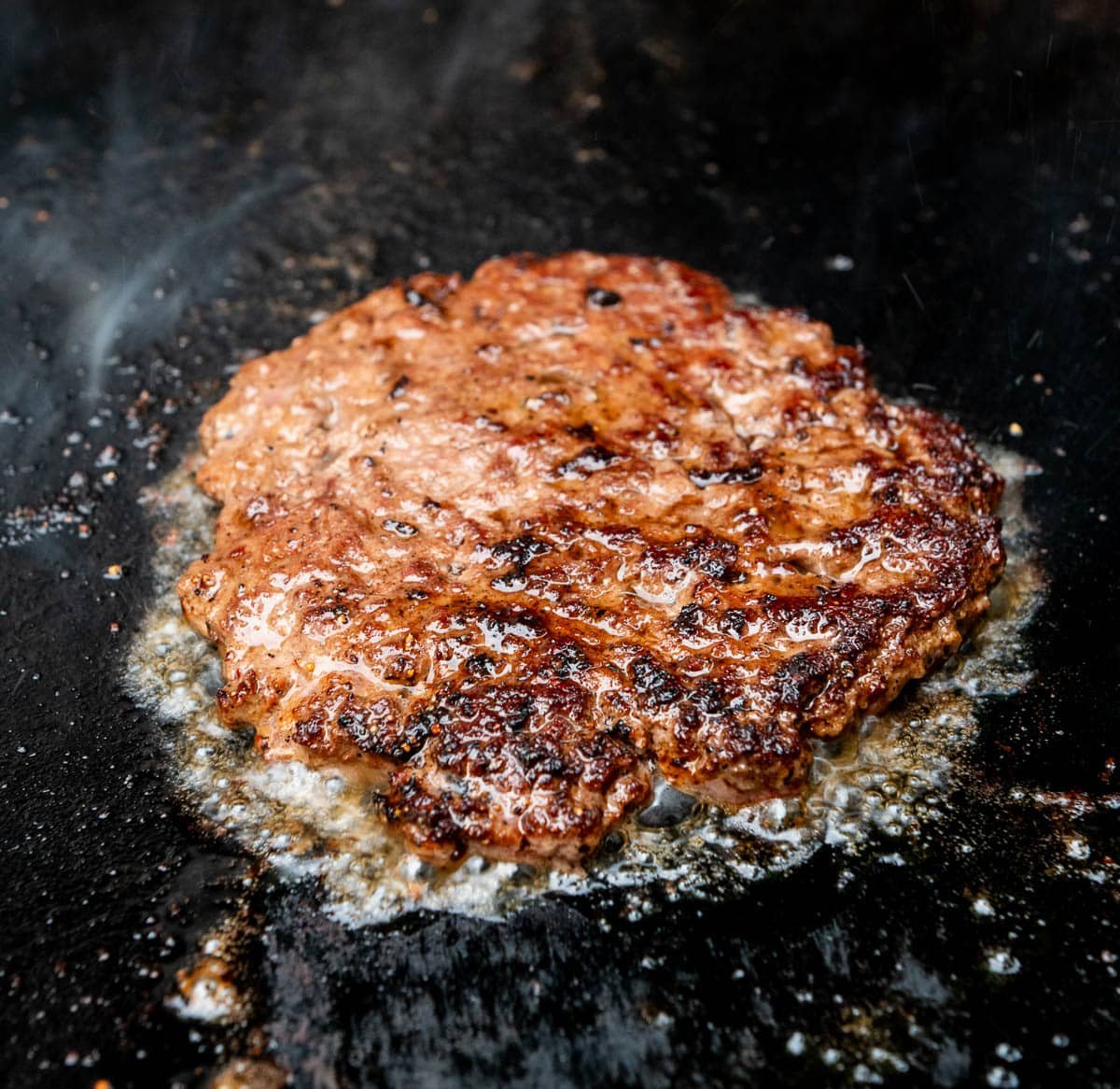 Cooked smash burger flipped to the other side.