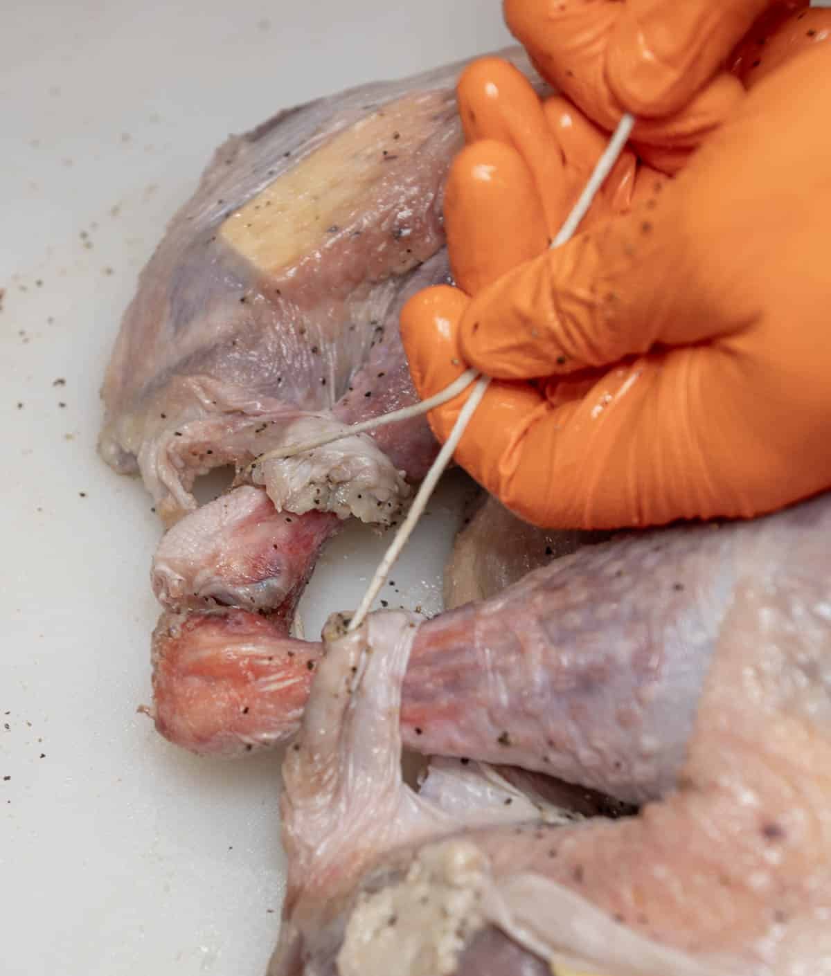 The turkey's legs are being tied together. 