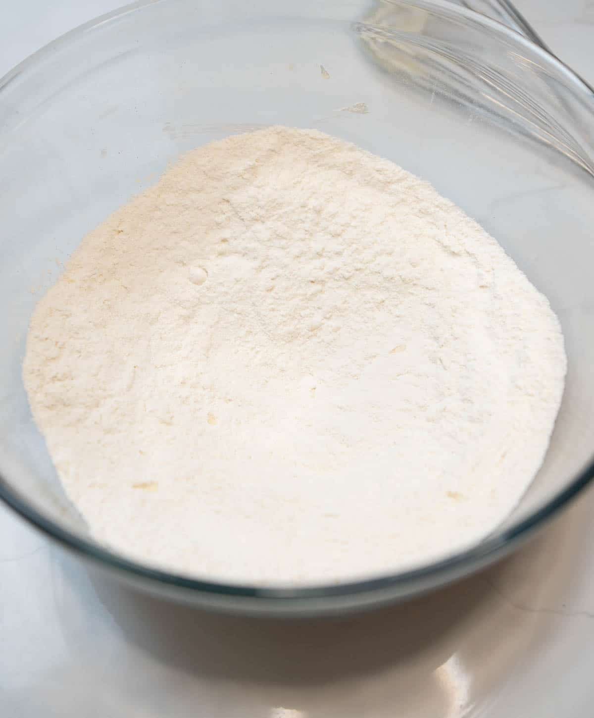 A large glass bowl of dry ingredients. 