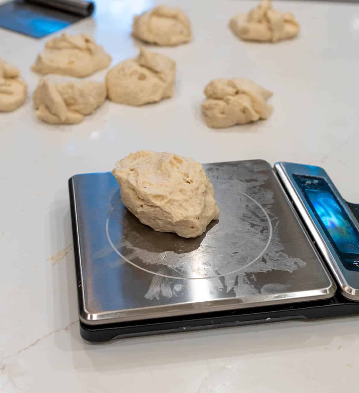 Individual pieces of dough weighted on a food scale. 