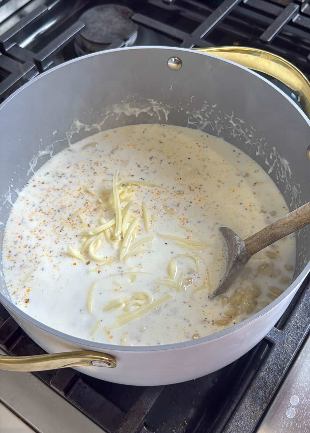 pot of boiling milk and macaroni noodles