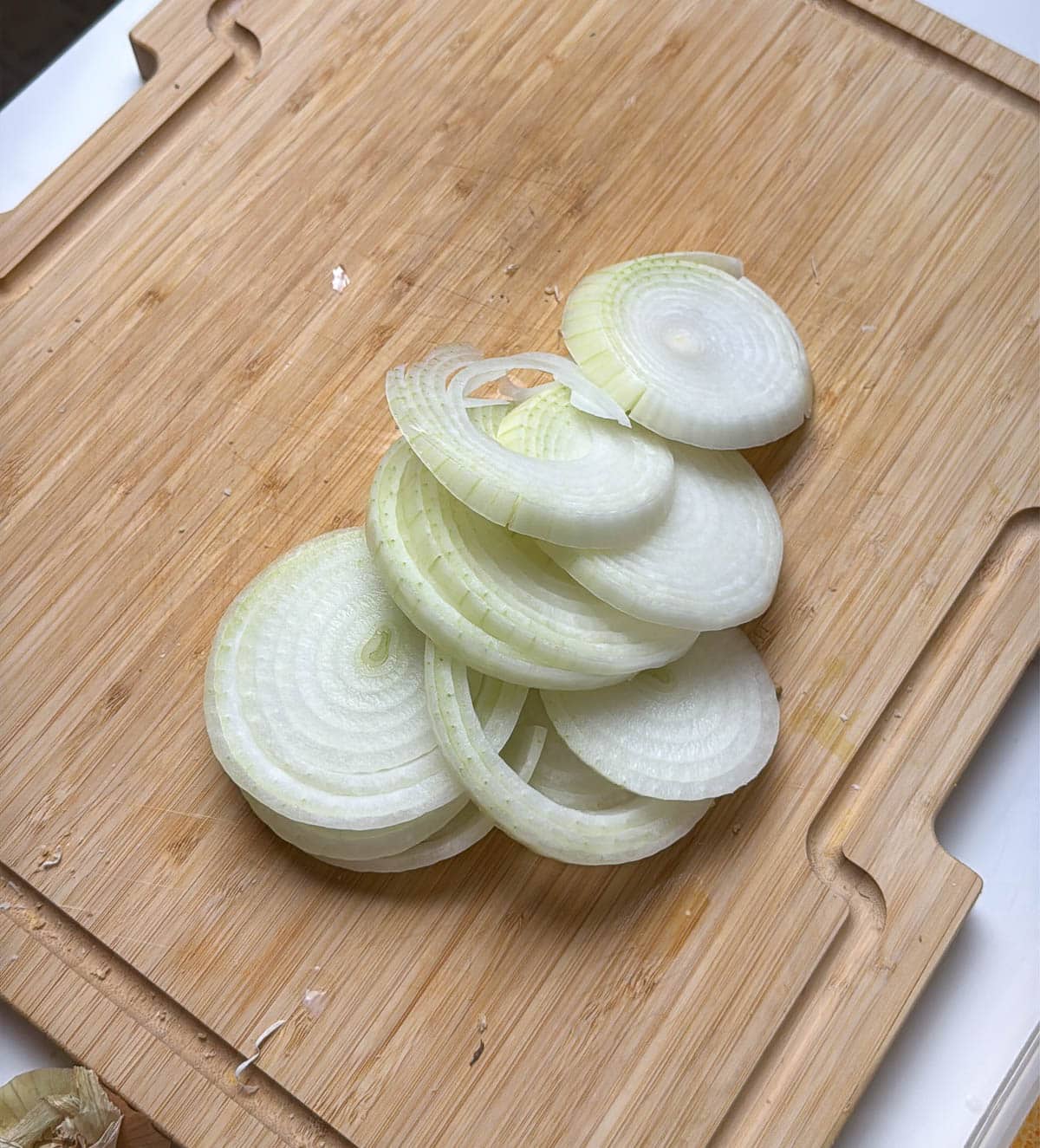 A sliced onion on a wooden cutting board.