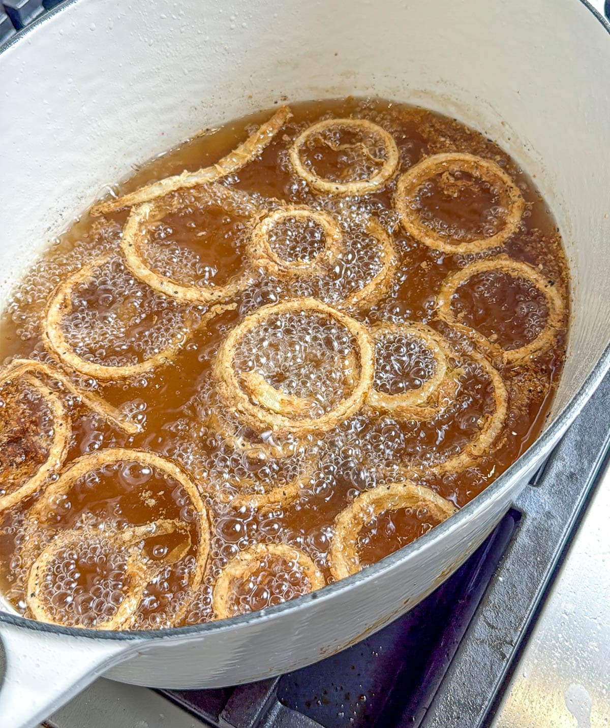 A large pot with the onions frying in oil.