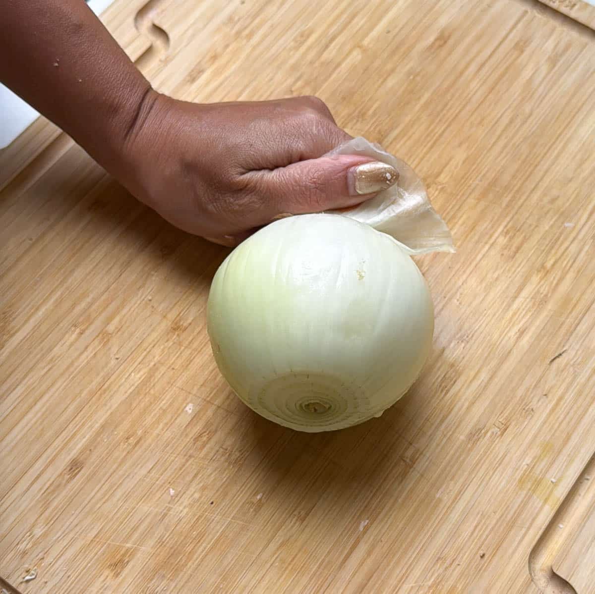 A photo of a washed and peeled yellow onion.