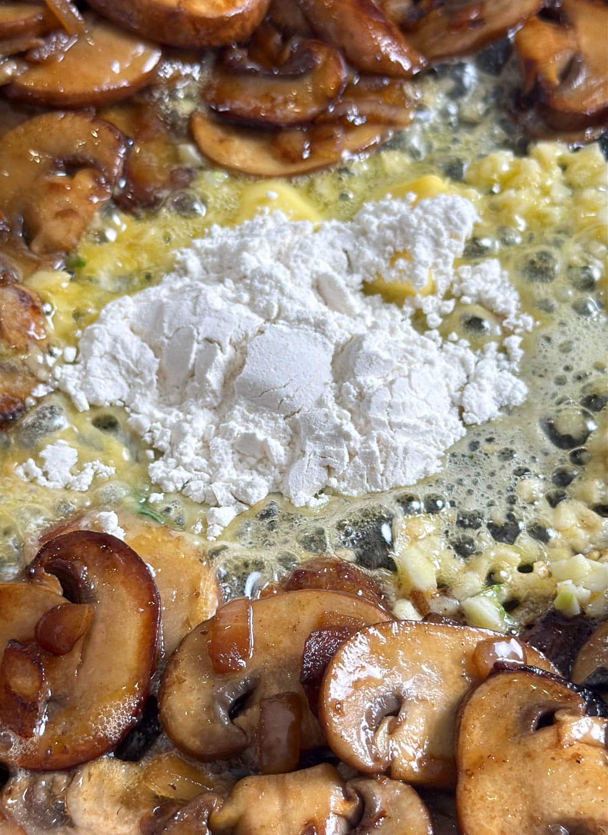 mixture of flour and butter cooking in a pan with mushrooms