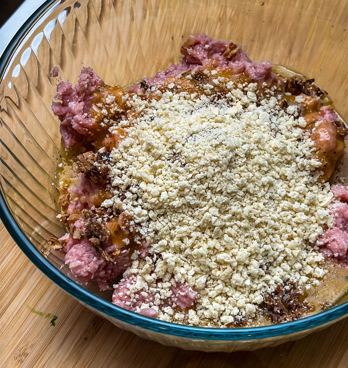 Wet ingredients, ground turkey, and bread crumbs are added to a bowl.