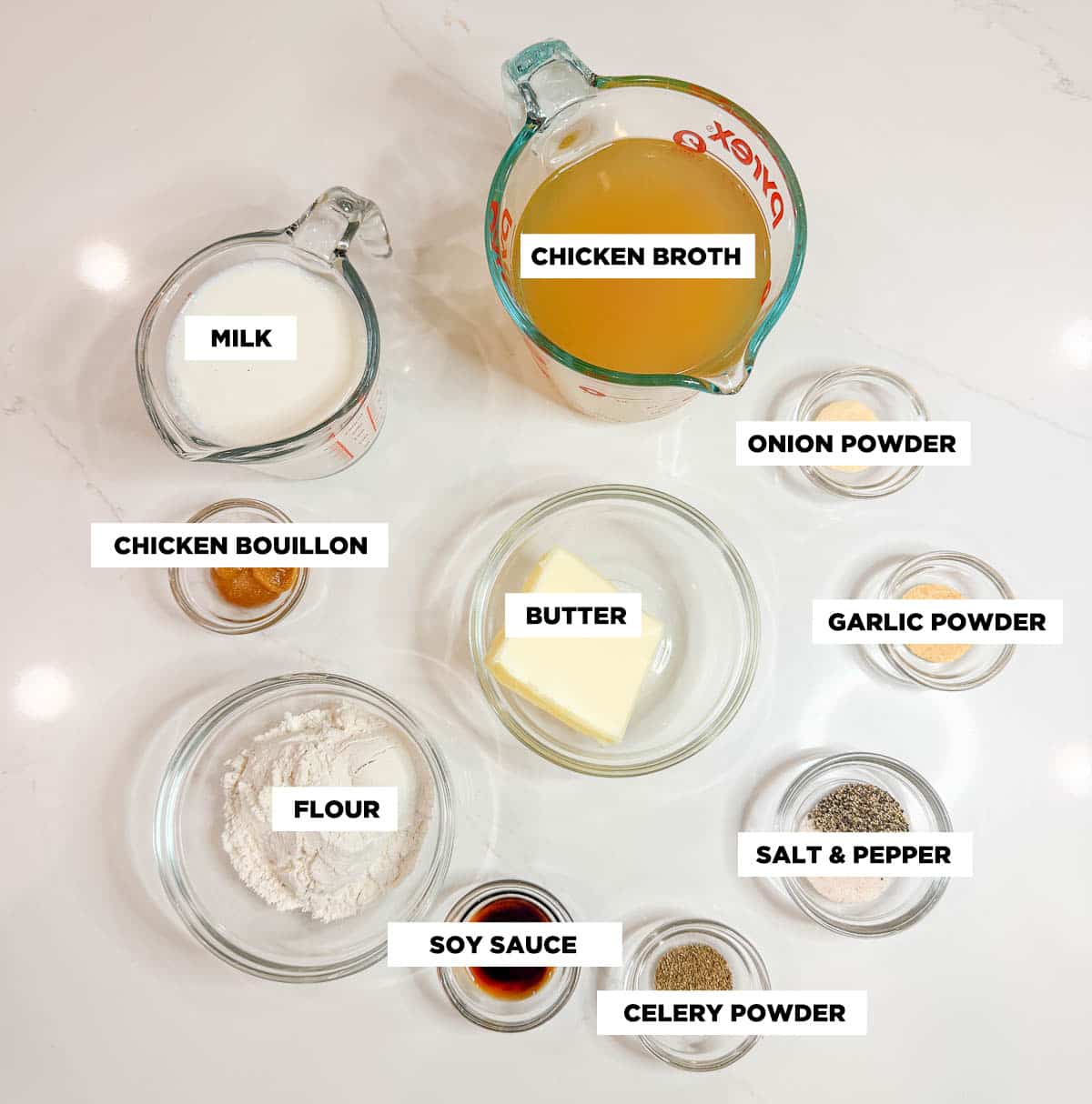 Ingredient shot for homemade cream of chicken soup, featuring: chicken broth, ilk, onion powder, garlic powder, chicken bouillon, butter, flour, soy sauce, celery powder and salt & pepper. 