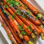 close up of honey glazed carrots on a white plate
