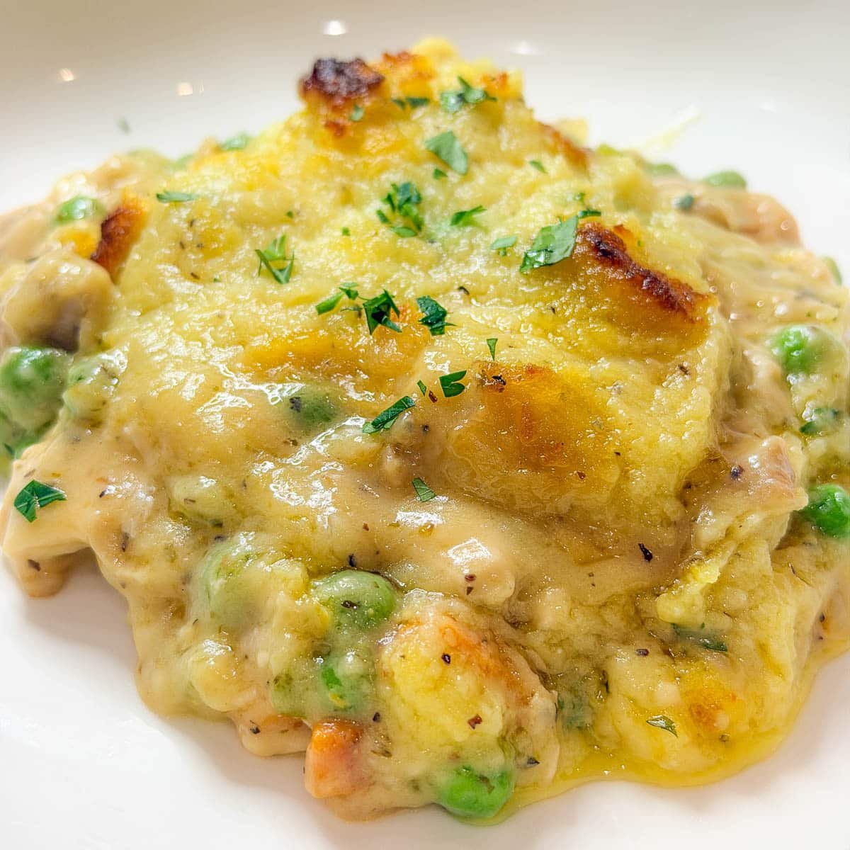 A close-up photo of a portion of Leftover Thanksgiving Casserole on a white plate.
