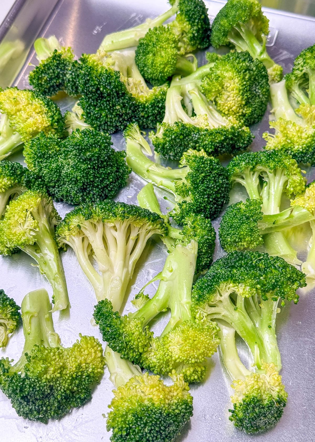 Broccoli florets arranged flat-side down on a baking sheet.